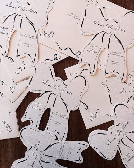 Wedding dress-shaped paper cutouts arranged on a dark wooden surface.