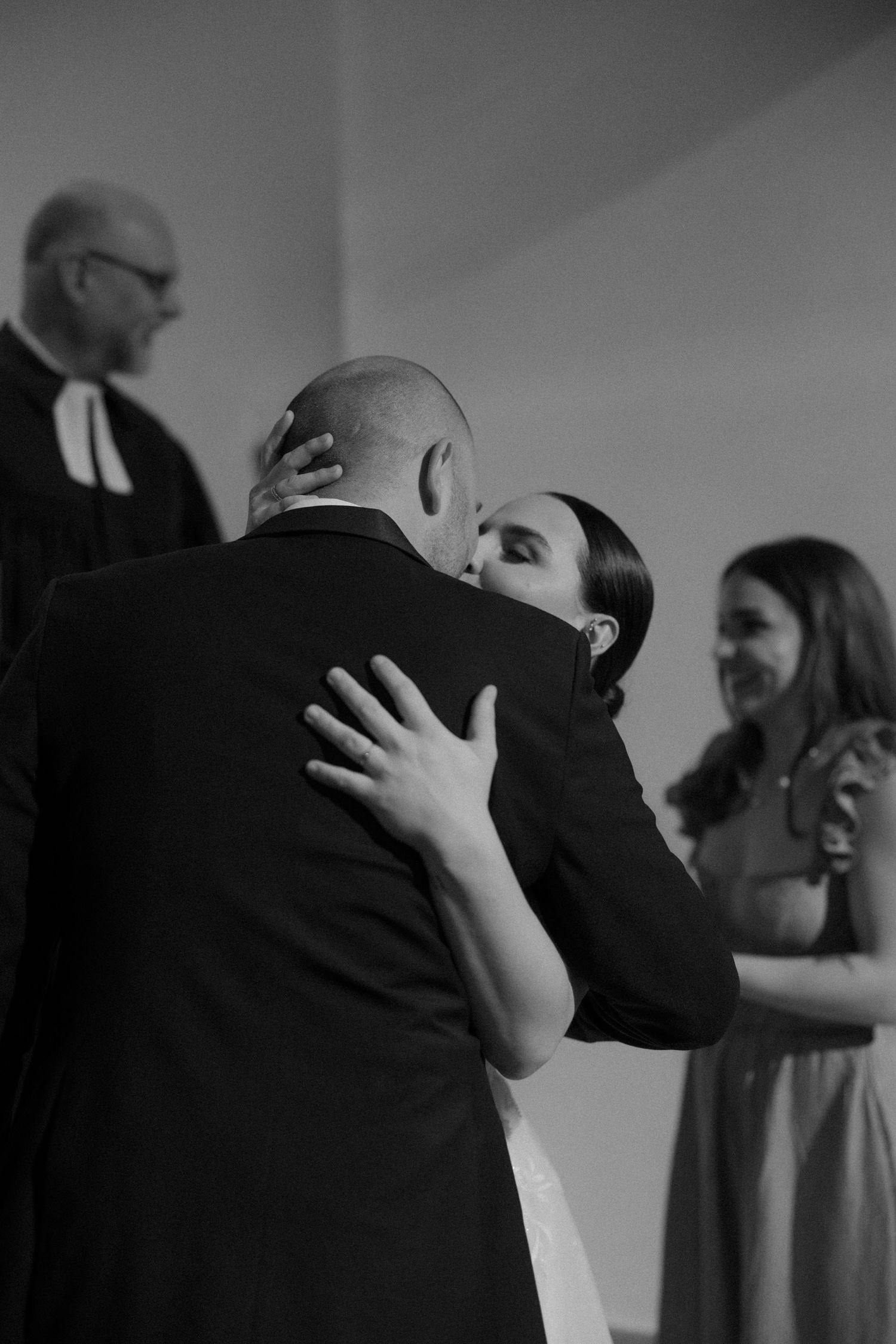 Emotional embrace during wedding ceremony with guests looking on.
