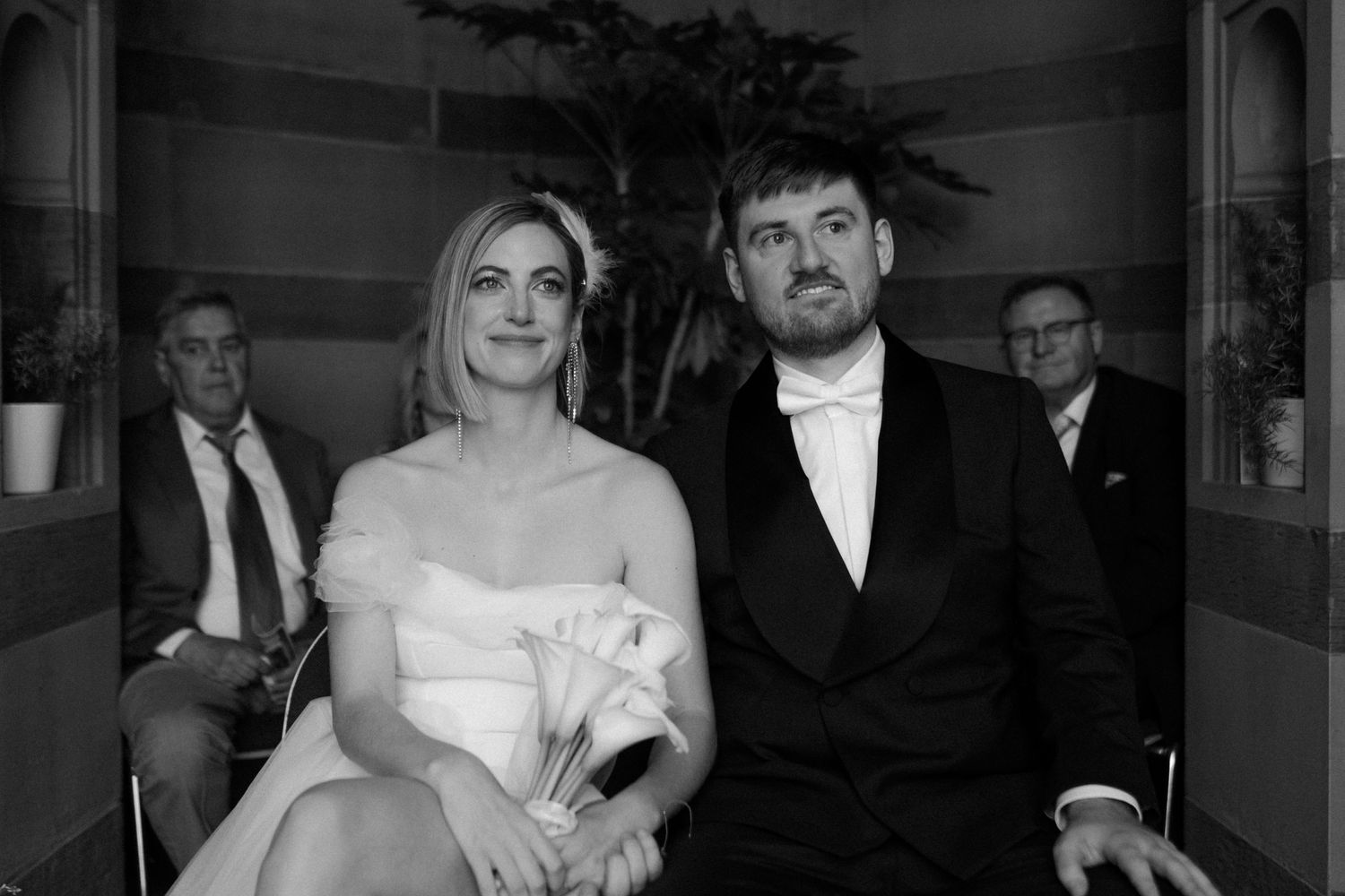 Interior wedding portrait in a classical stone colonnade setting.