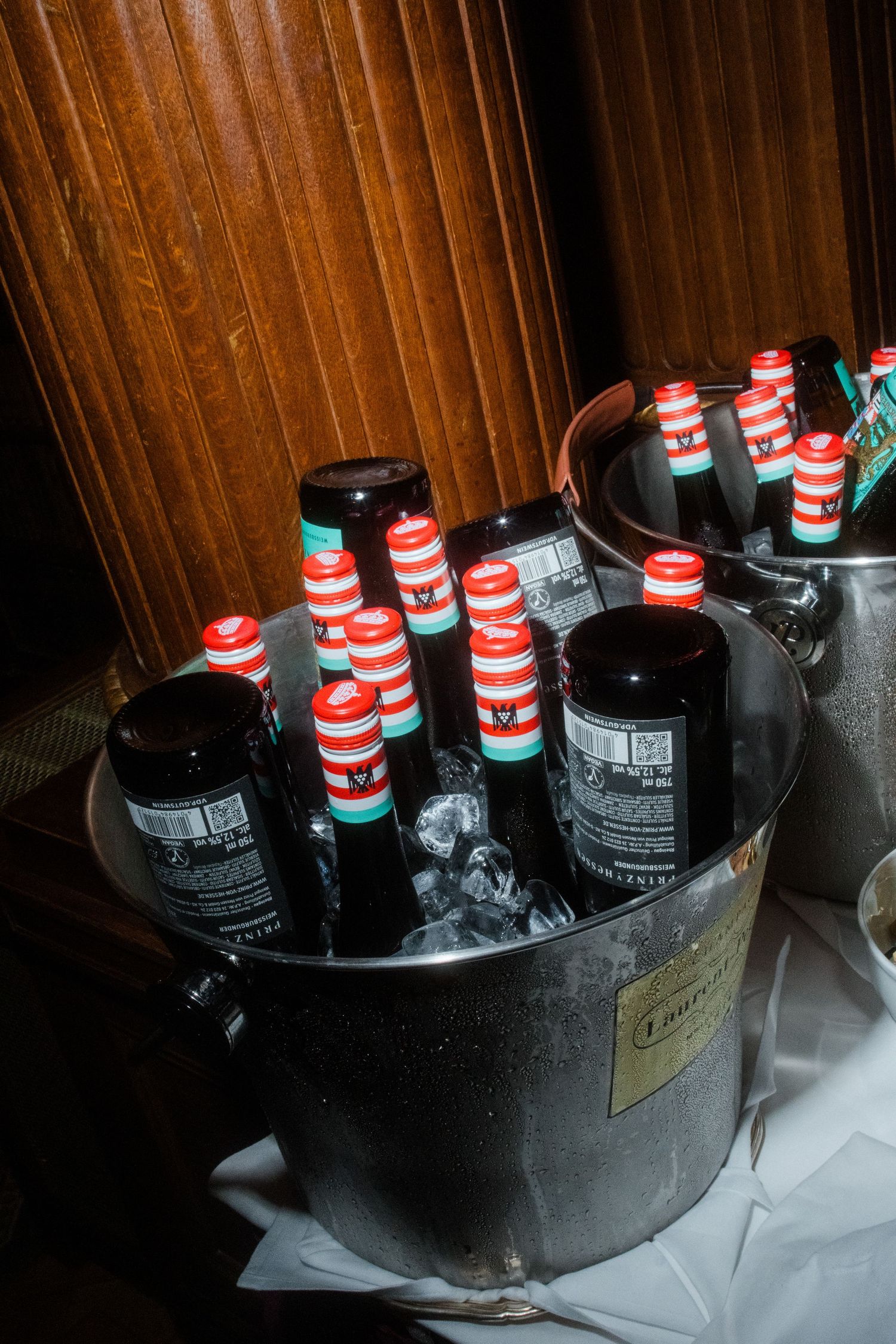 Ice bucket filled with bottles of beer chilling at an event.