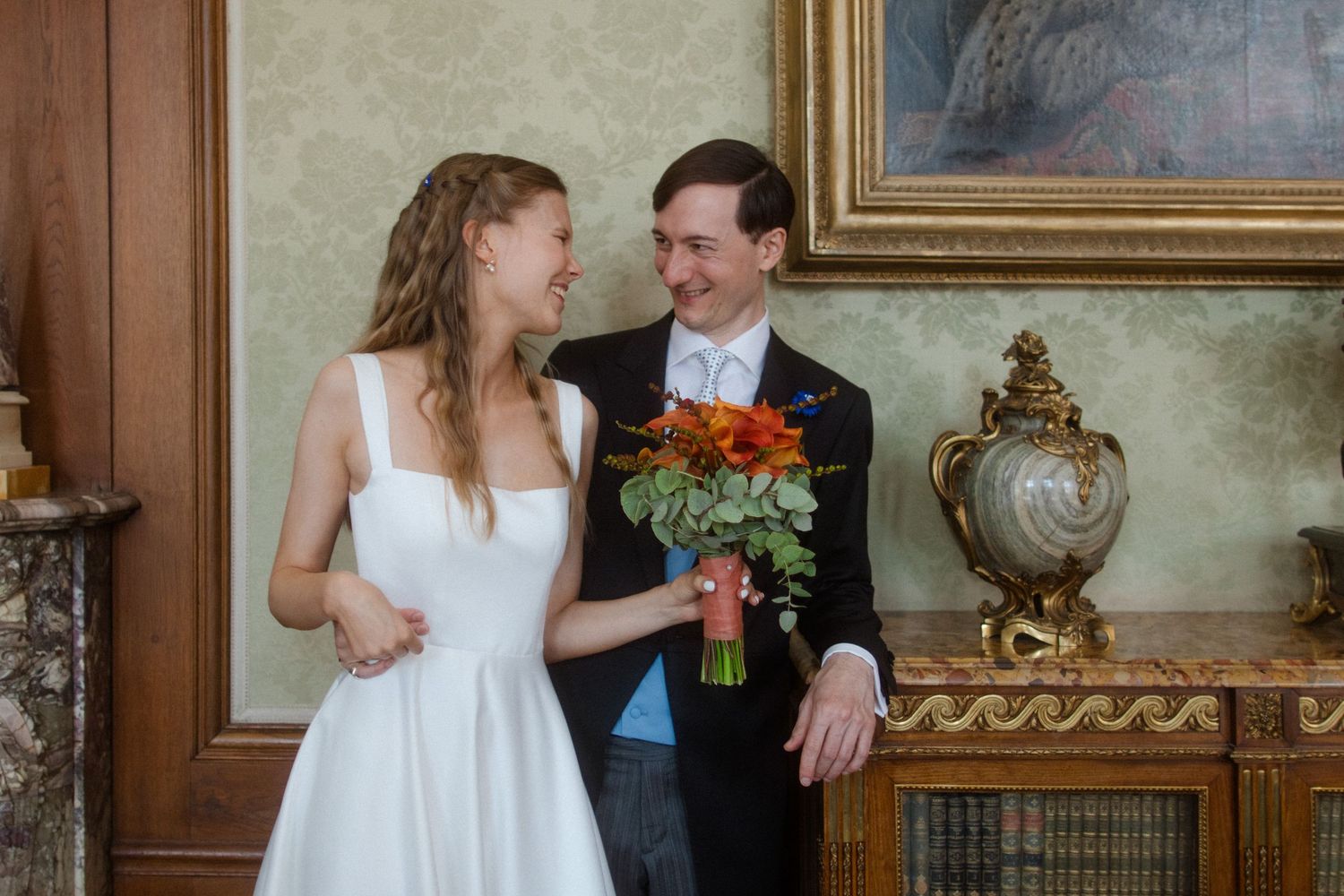Elegant indoor wedding photoshoot in a historic room with ornate decor and wooden details.