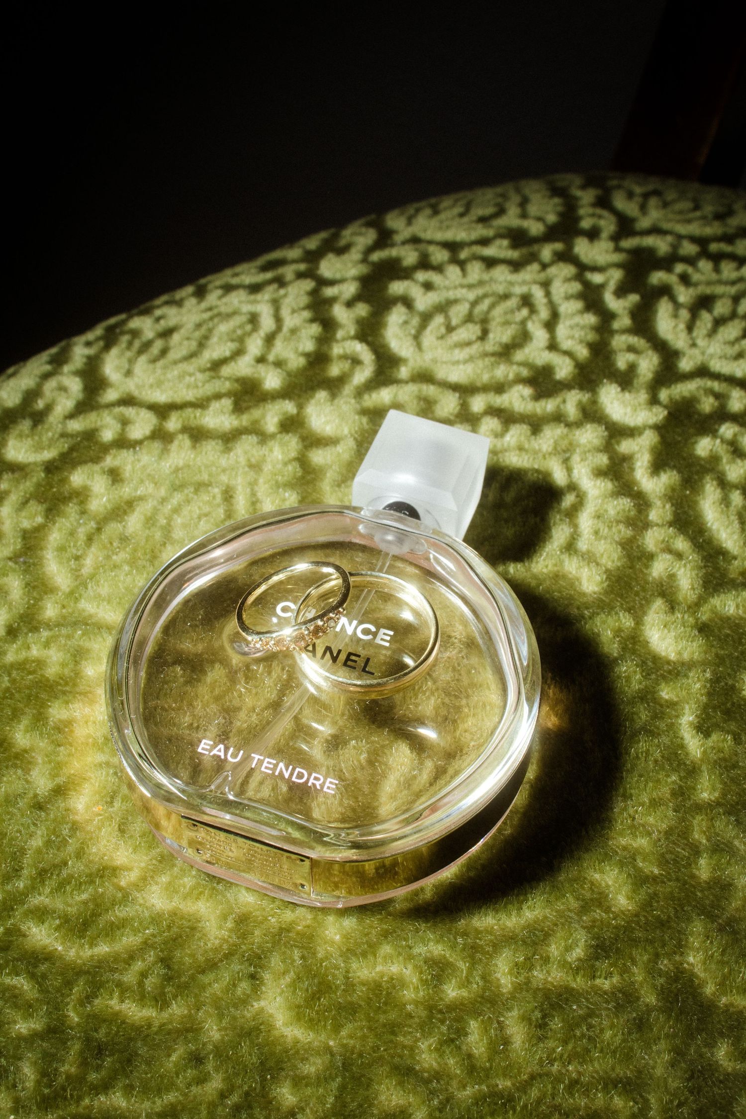 Chanel perfume bottle photographed on green velvet surface.