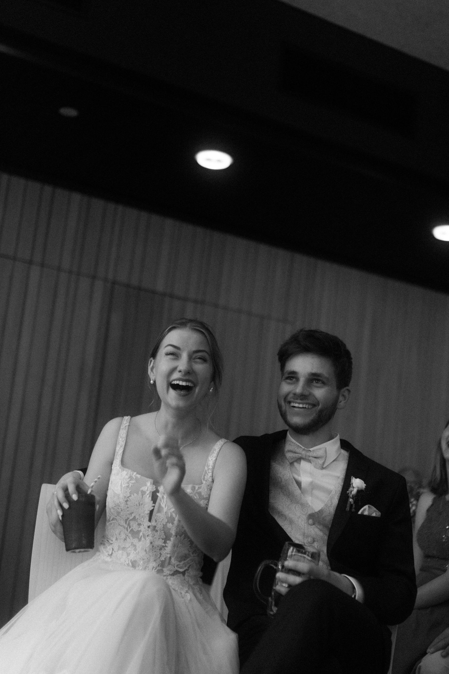 A joyful black and white moment captured during a wedding reception celebration.