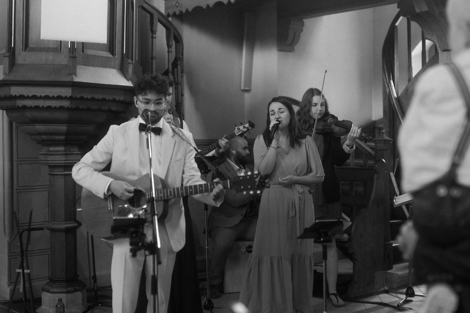 Black and white photo of musicians performing in a vintage setting.