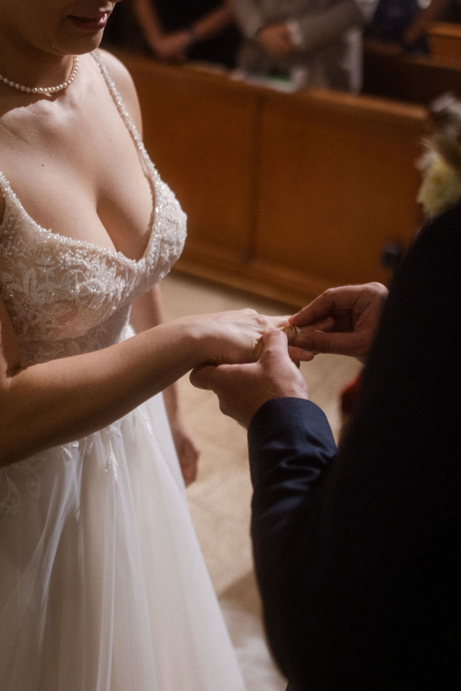 Close-up of wedding ring exchange during ceremony.