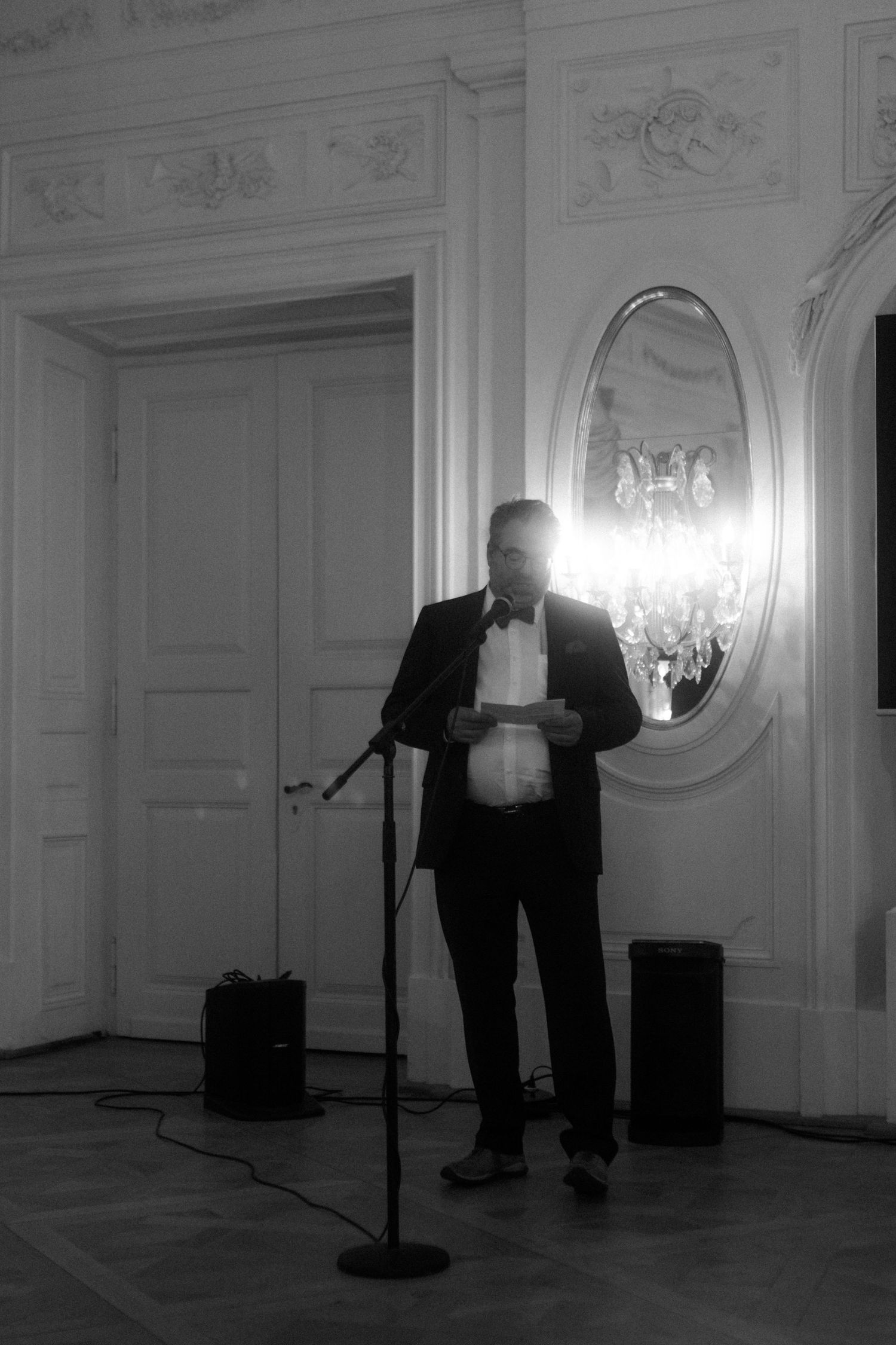 speech of the father of the bride in an elegant white ballroom with crystal chandeliers.