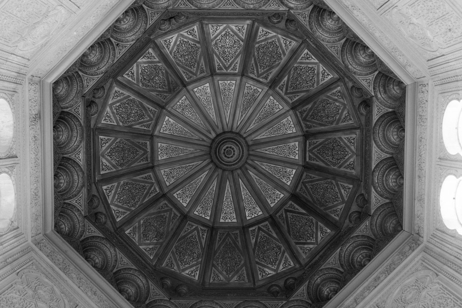Historic octagonal dome ceiling with intricate radial patterns in monochrome.