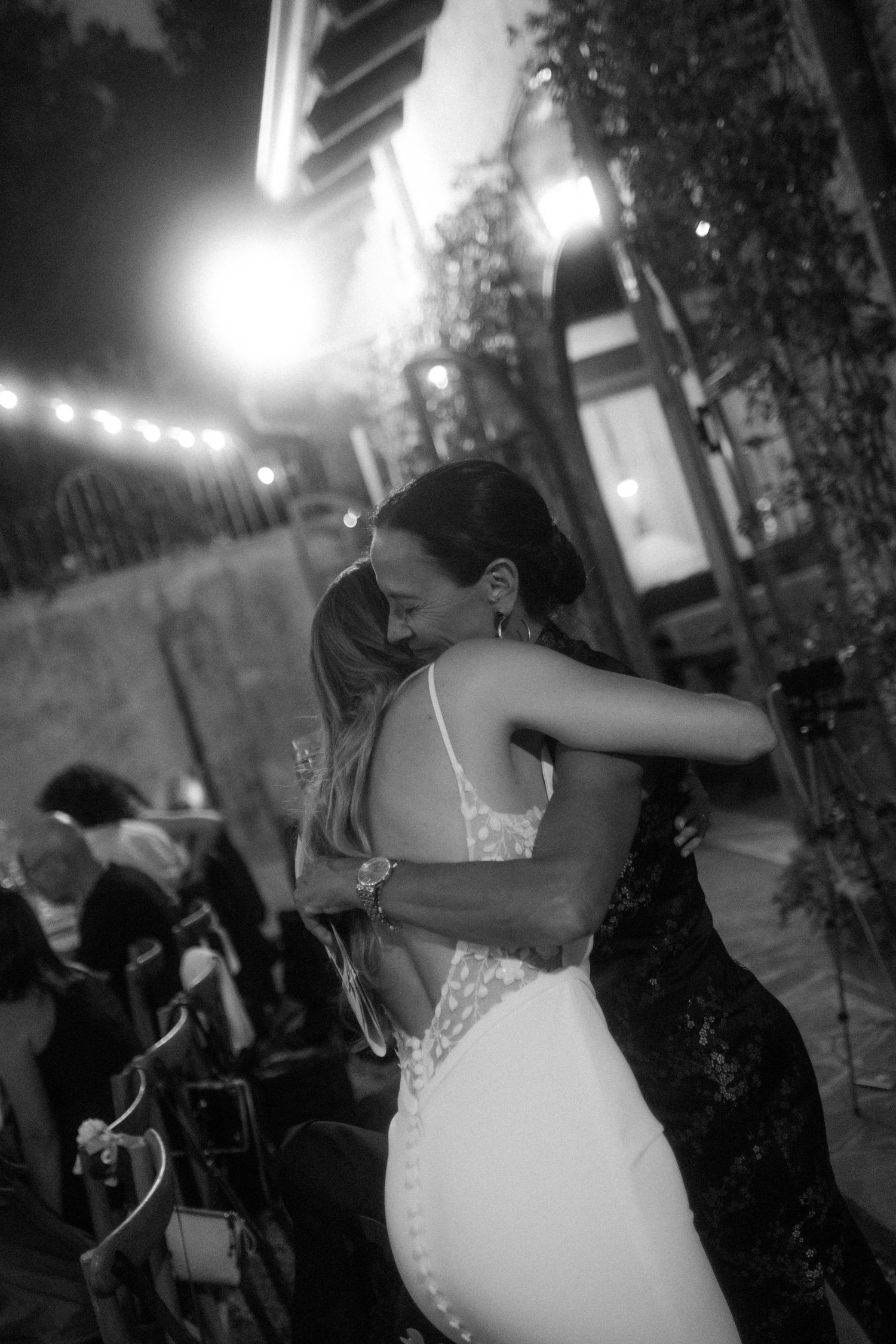 Dancing couples celebrate at a romantic outdoor evening reception.