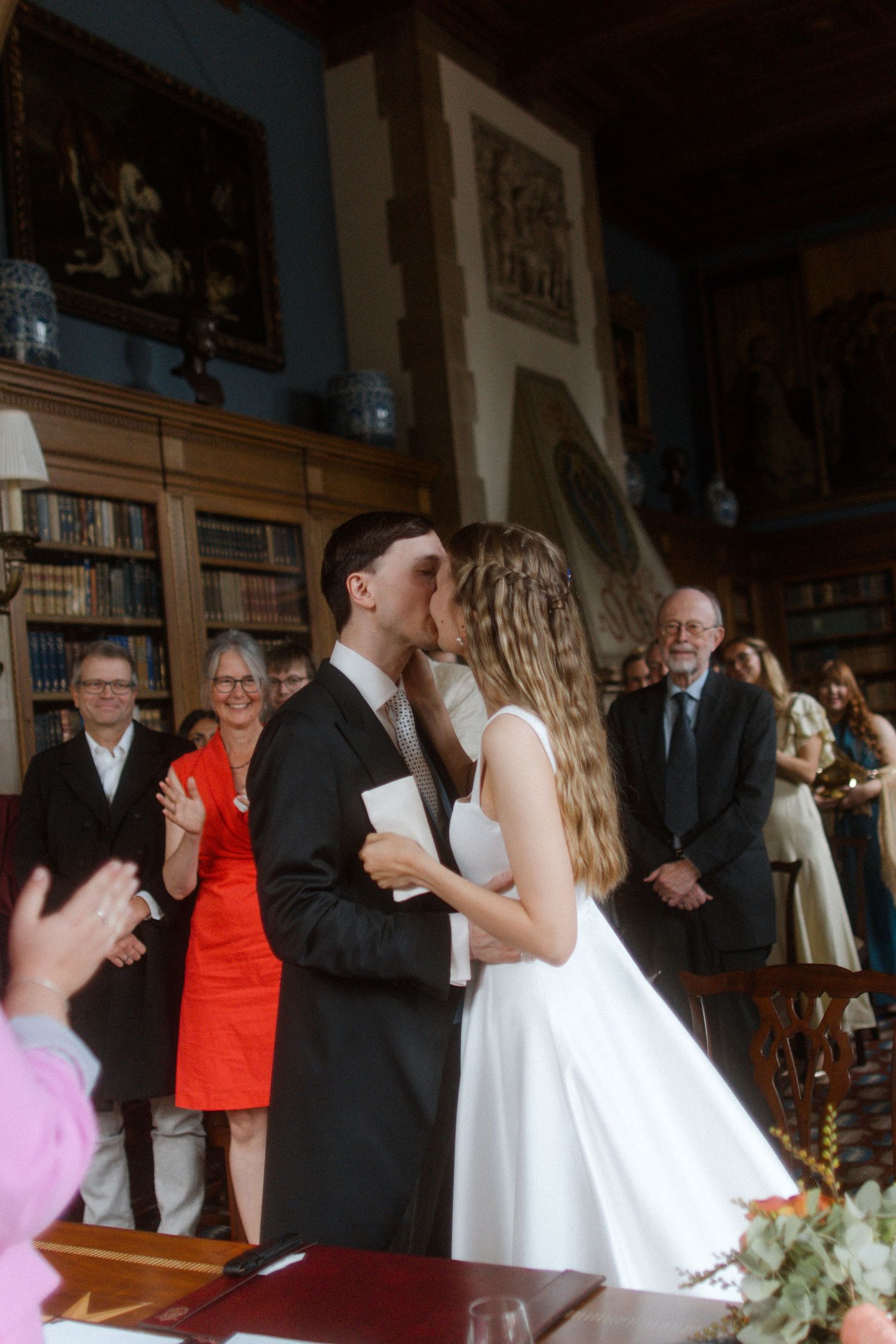 Wedding ceremony in a historic venue with guests watching the couple dance.