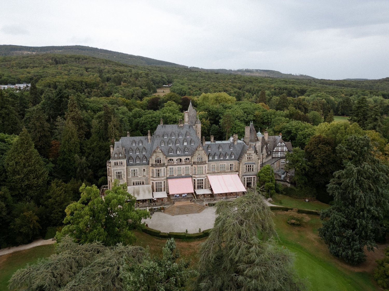 Aerial view of a grand castle estate surrounded by lush green countryside.