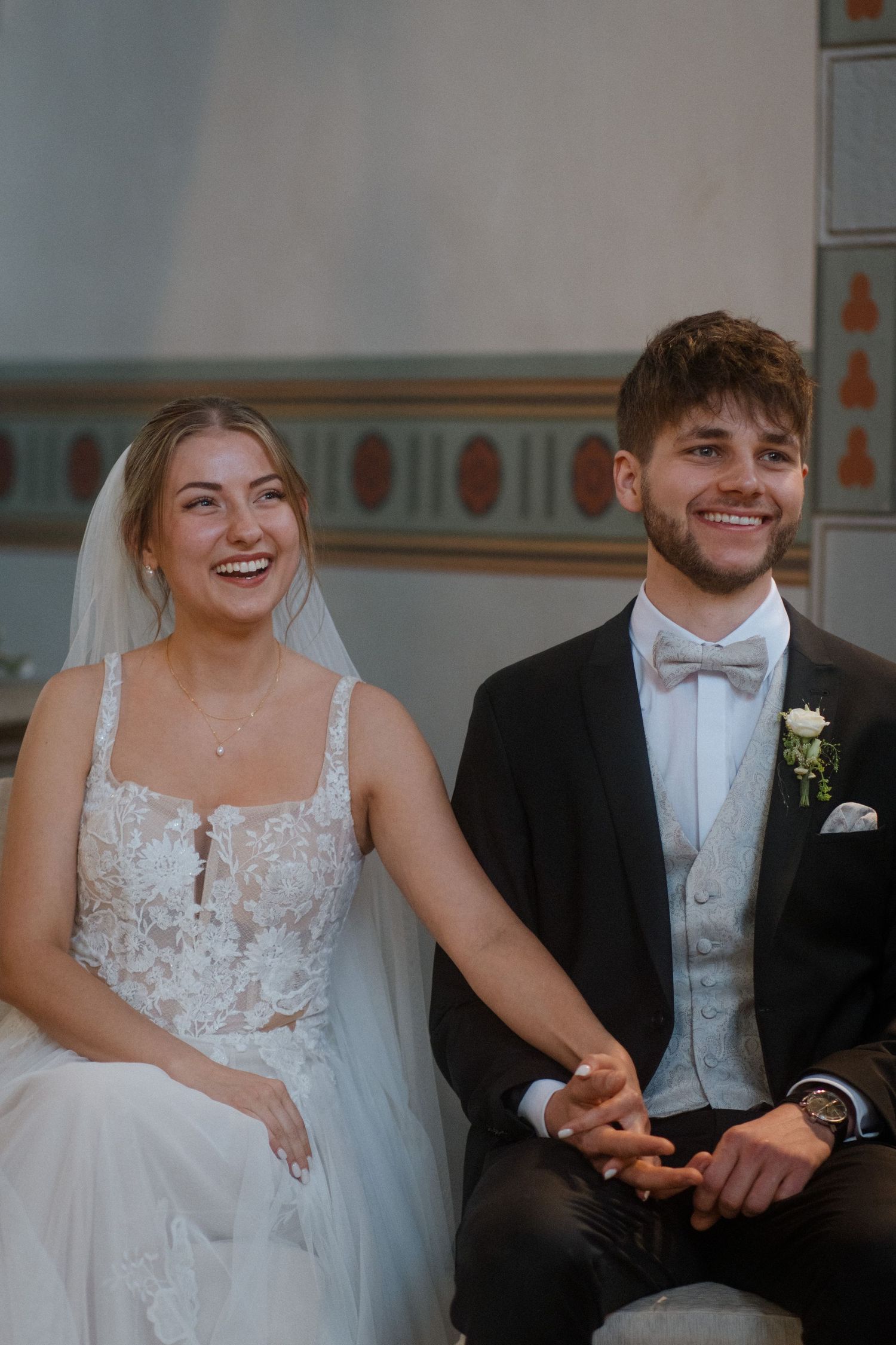 A wedding couple shares a joyful moment during their church ceremony.
