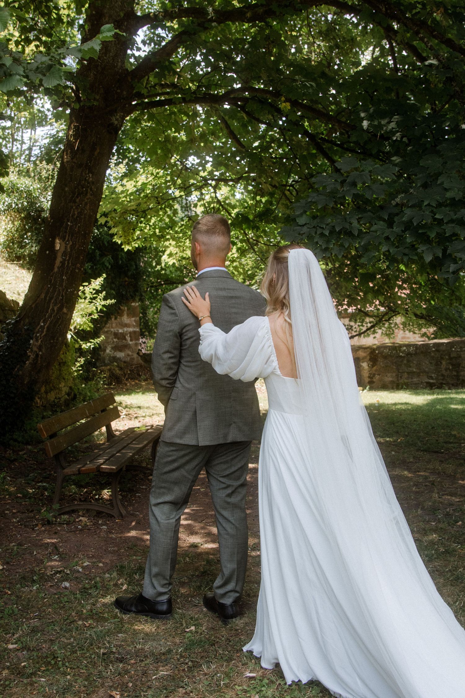 Wedding couple walking together through a garden setting.