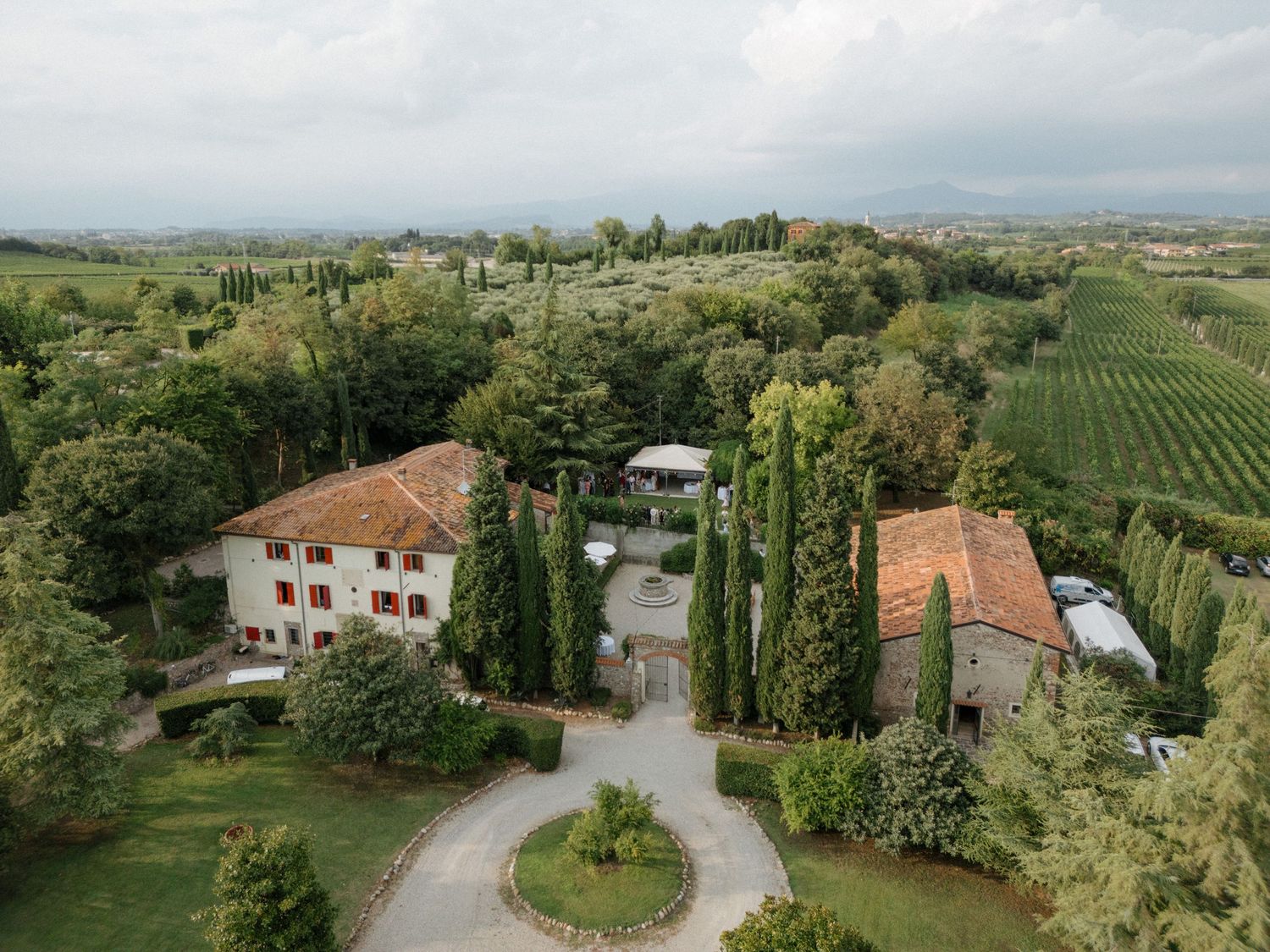Panoramic view of Tuscan countryside with scattered villas and cypress trees.