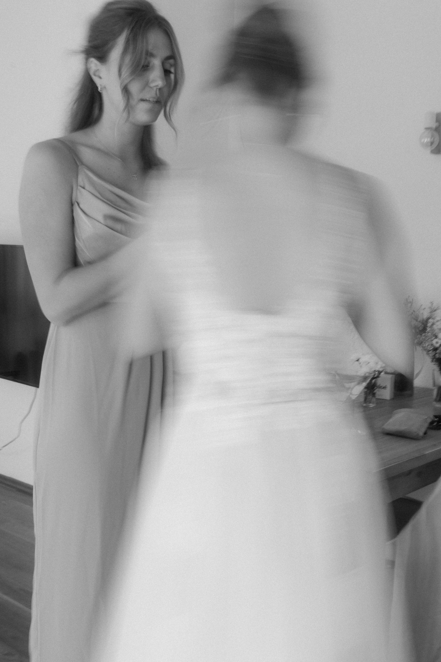 An artistic blurred motion capture of wedding preparation with soft lighting and elegant dresses.