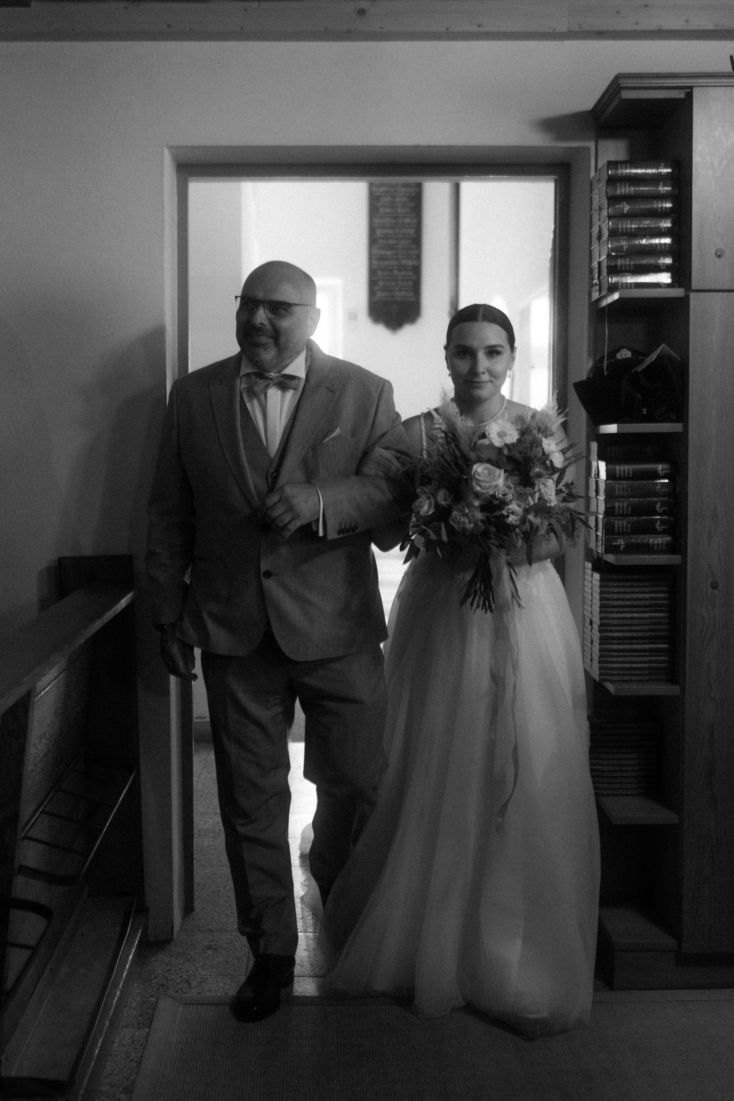 Black and white portrait in church hallway with traditional architecture.
