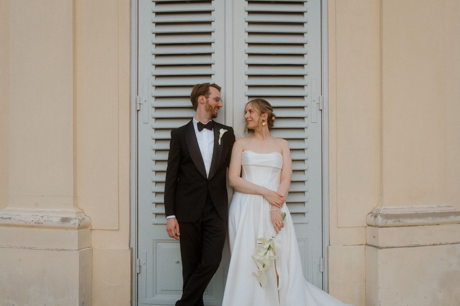 Romantic wedding portraits against a backdrop of cream shuttered doors.