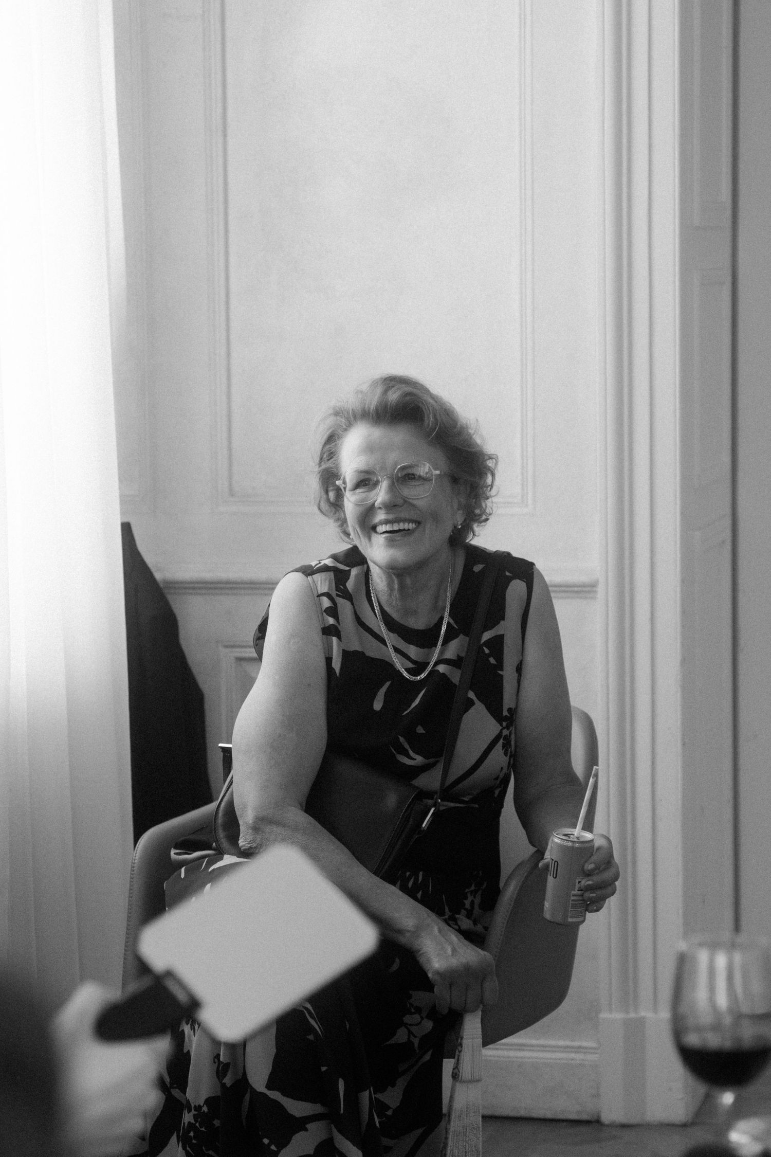 Black and white candid photo capturing laughter and joy at a social gathering.