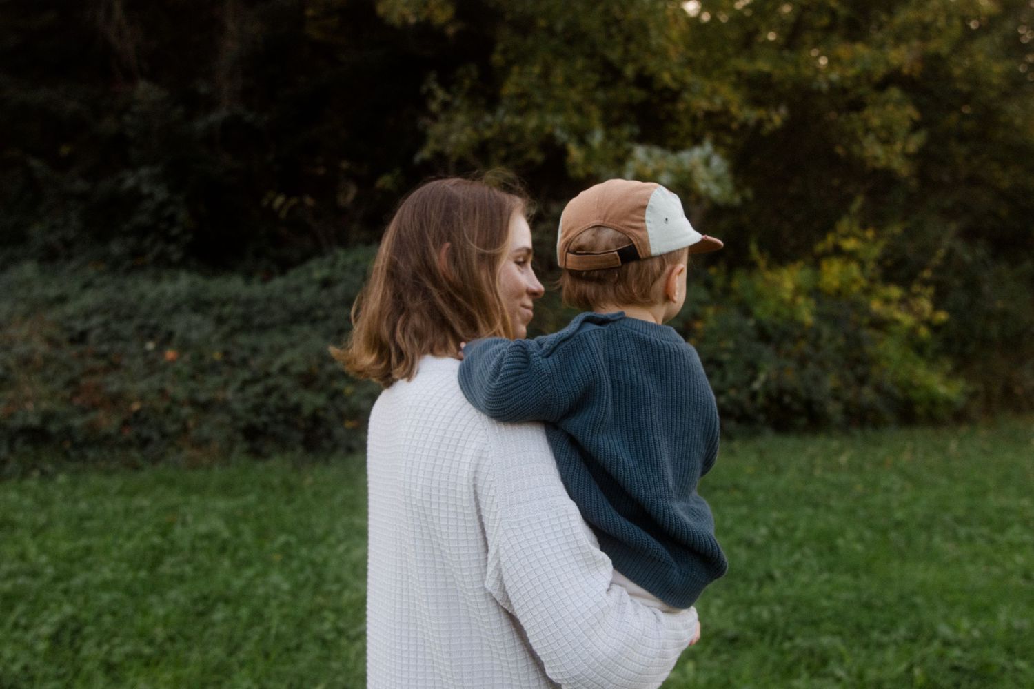 Family walking together outdoors during autumn with trees in the background.