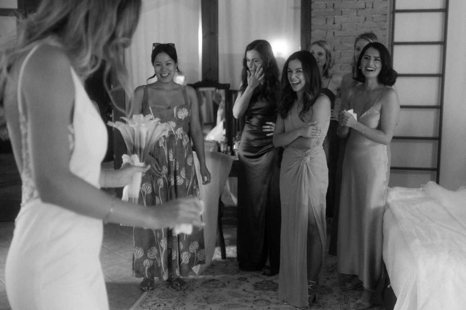People in formal attire gather around during a wedding celebration indoors.