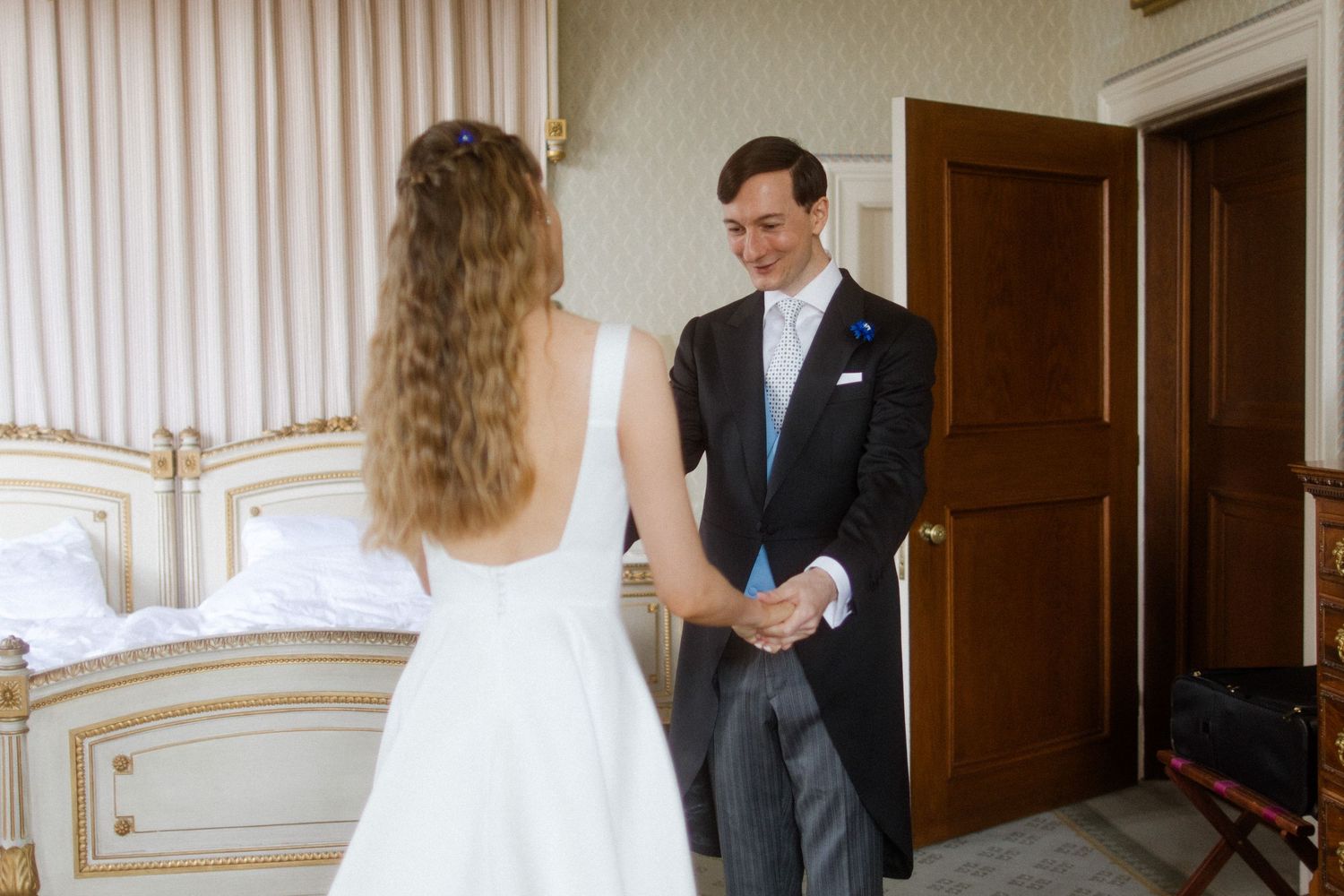 Wedding preparation scene in bright room with traditional furniture and decor.