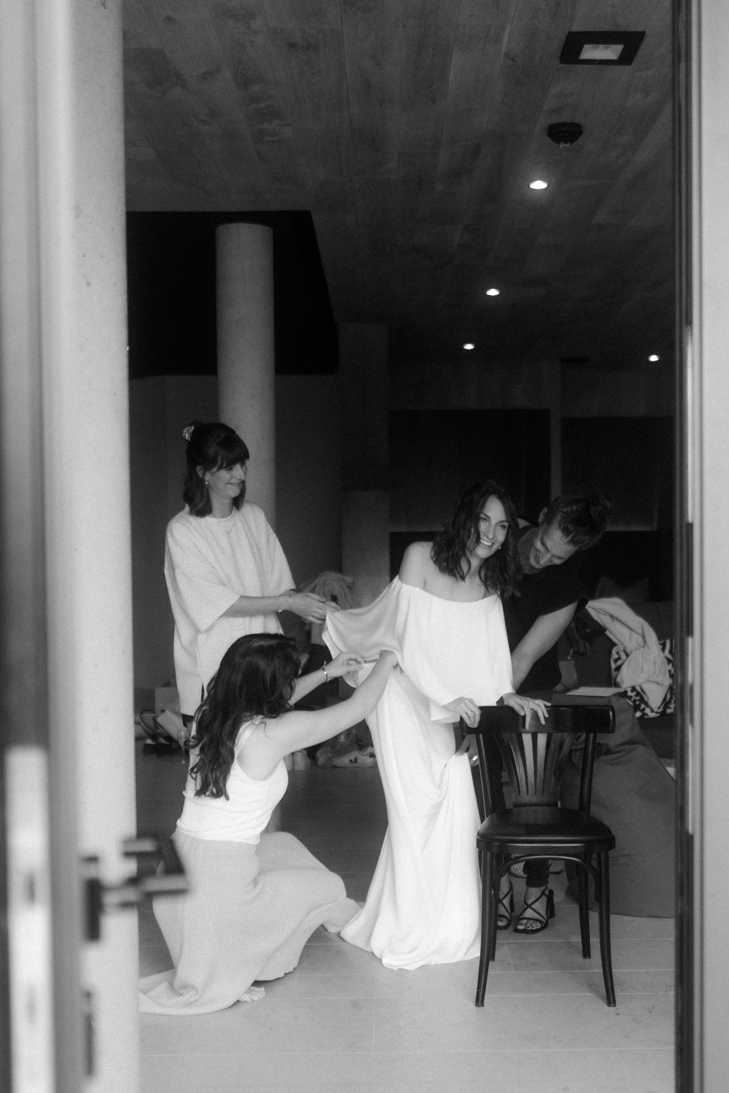 People in white clothing performing an artistic dance or movement piece in a minimalist space.