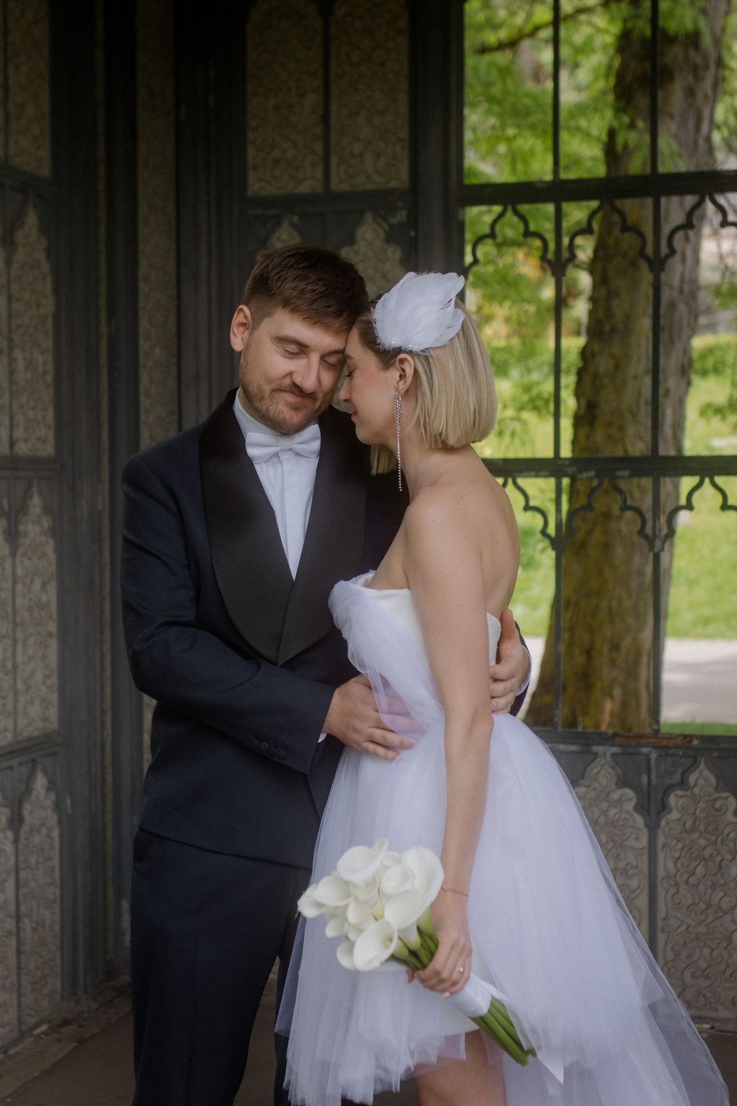 Intimate wedding moment showing couple embracing in an ornate stone alcove.