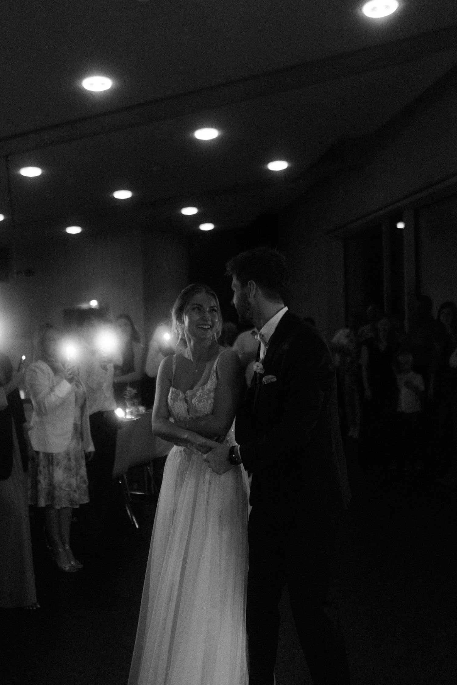 An intimate black and white moment between a couple during their wedding reception.