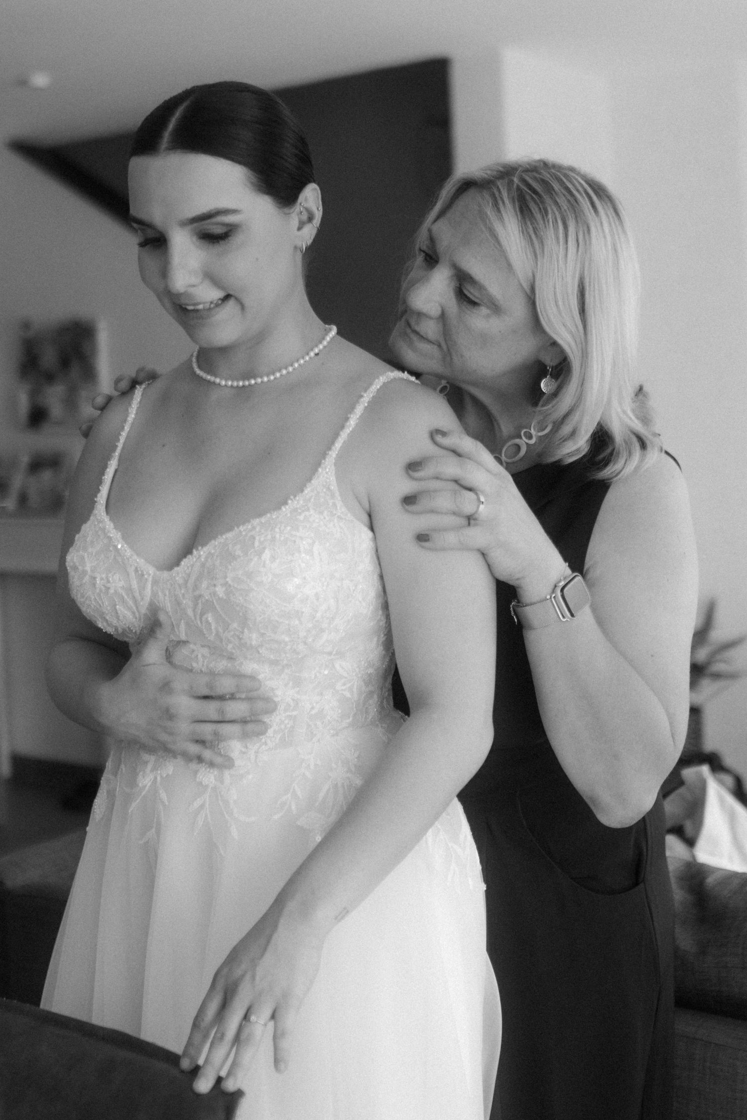 Black and white moment of emotional support during wedding dress fitting.