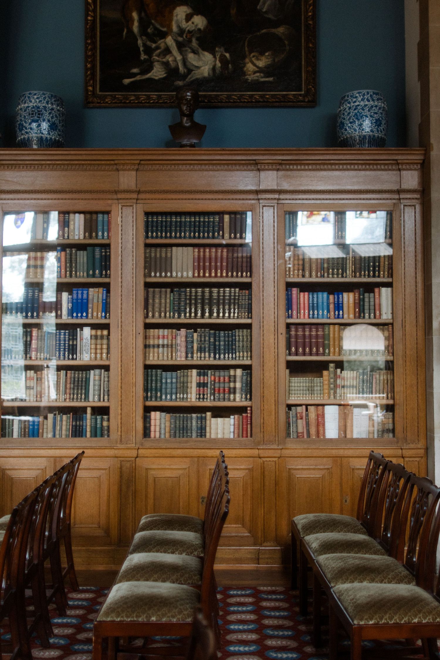 Traditional library interior with wooden paneling and rows of antique books.