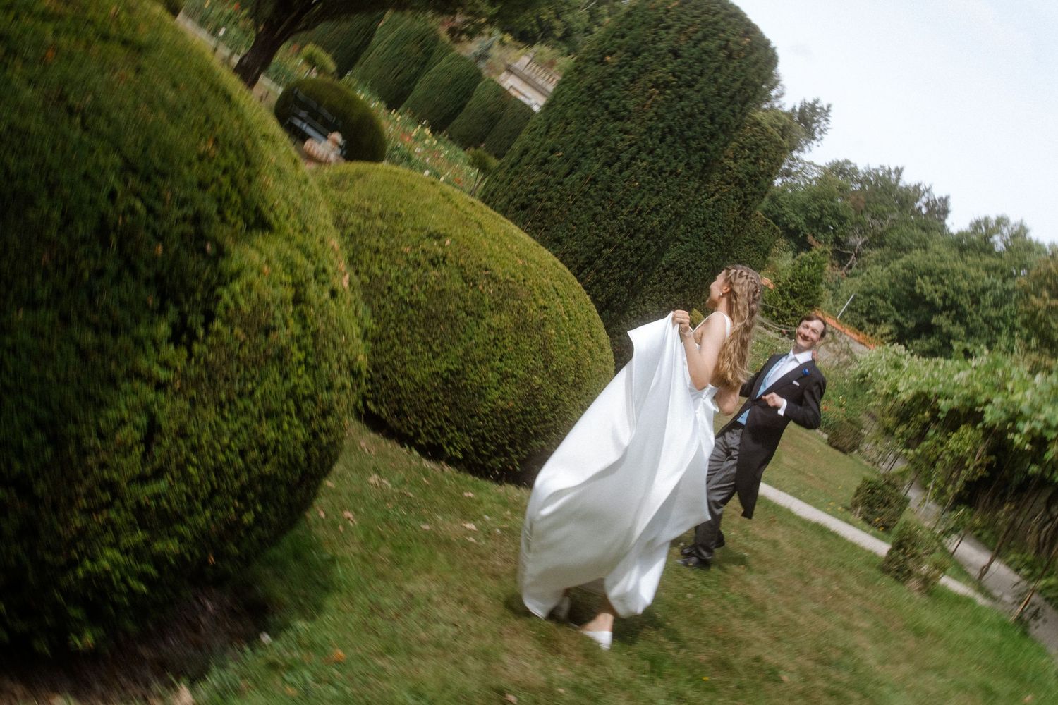 A wedding photo sequence in a manicured garden with hedges and greenery.