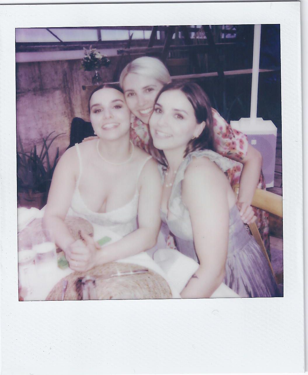 Three friends share a joyful moment together in a casual indoor setting.