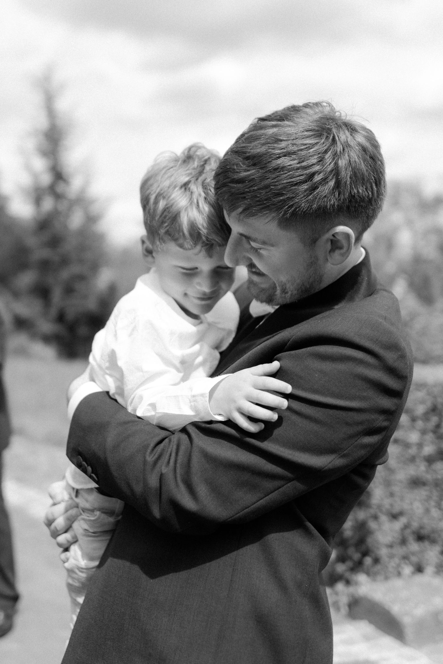 A tender black and white moment shared between two people at an outdoor event.