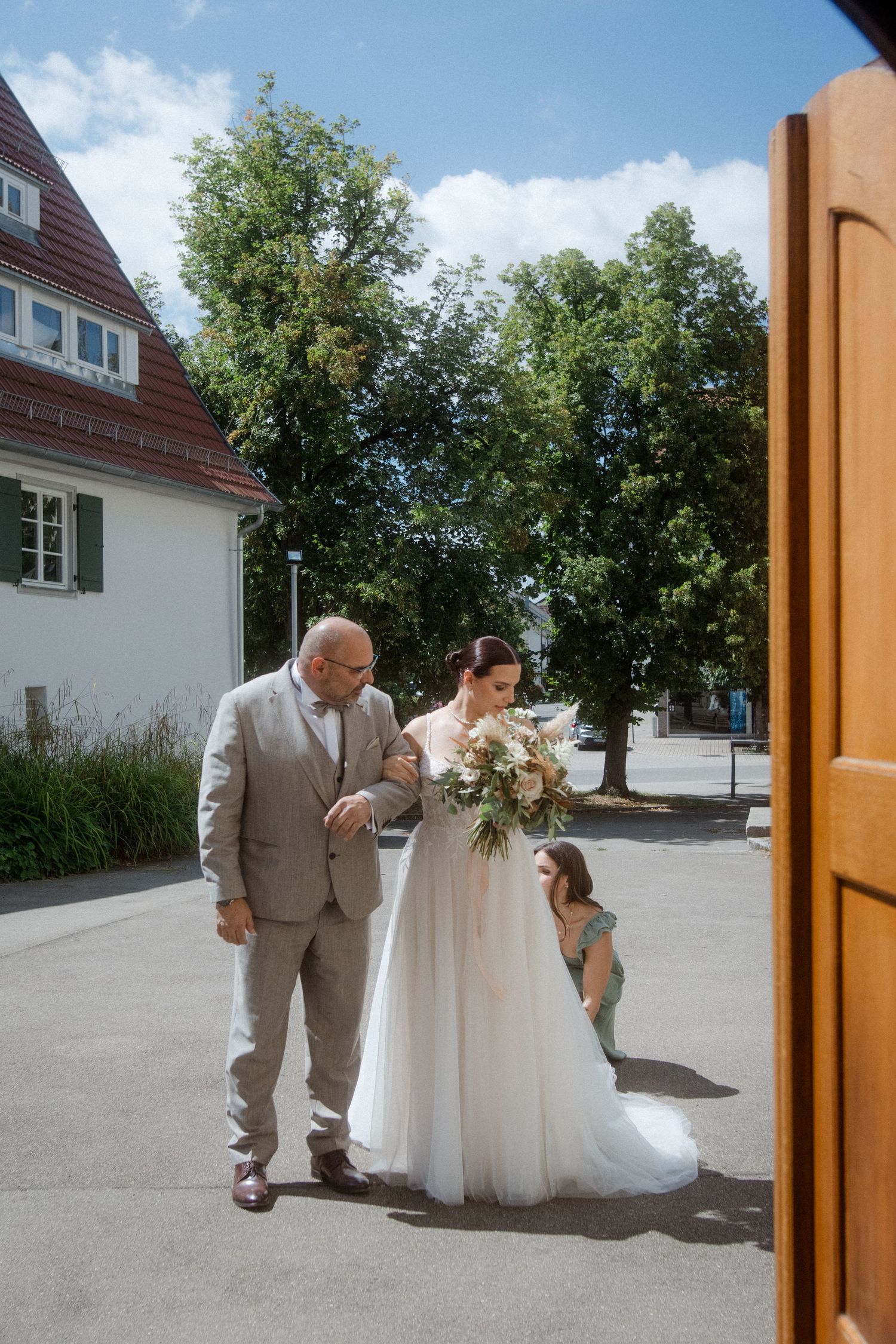 Wedding party walking through doorway of traditional German building.