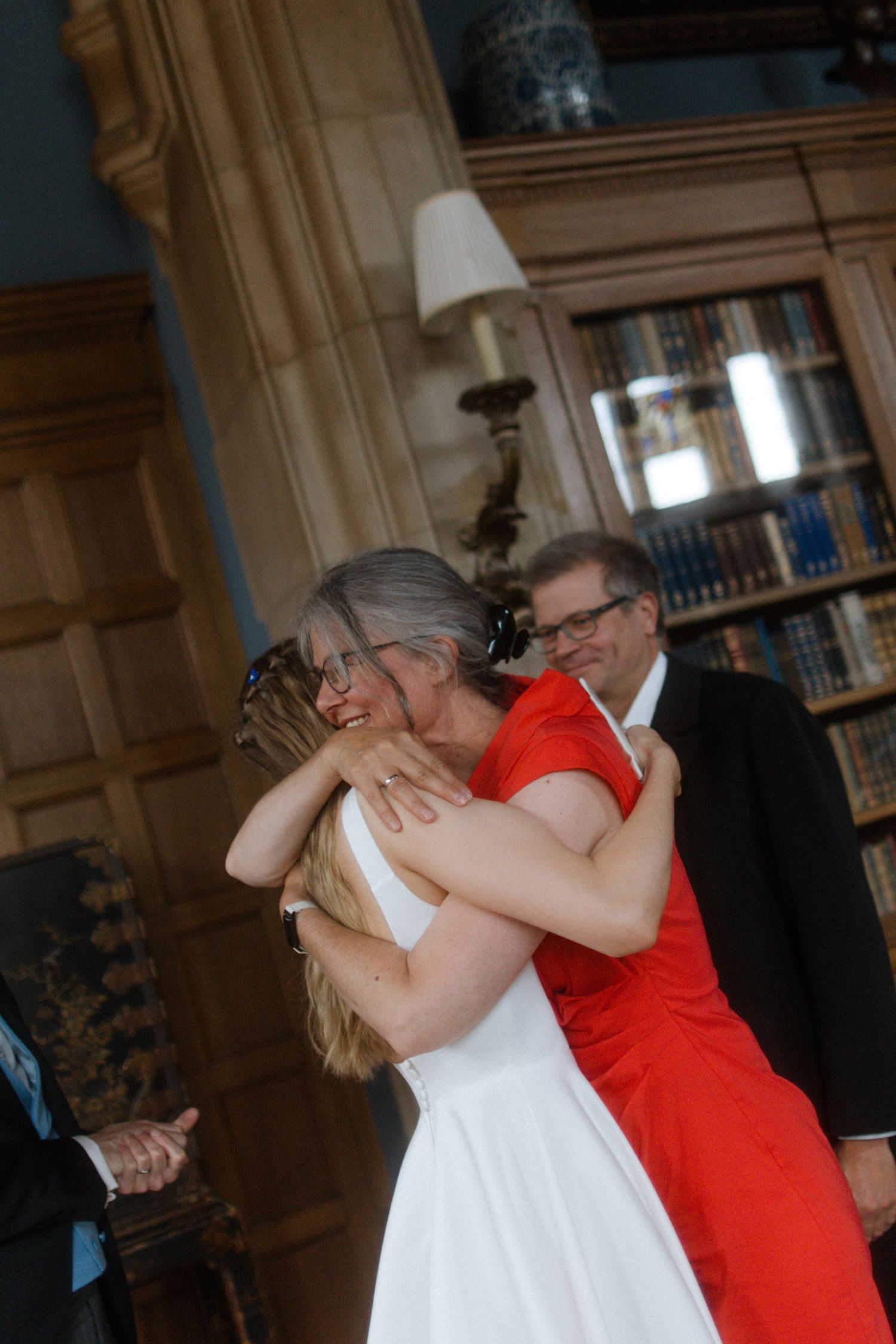 Wedding guests embracing during an emotional moment at the ceremony.