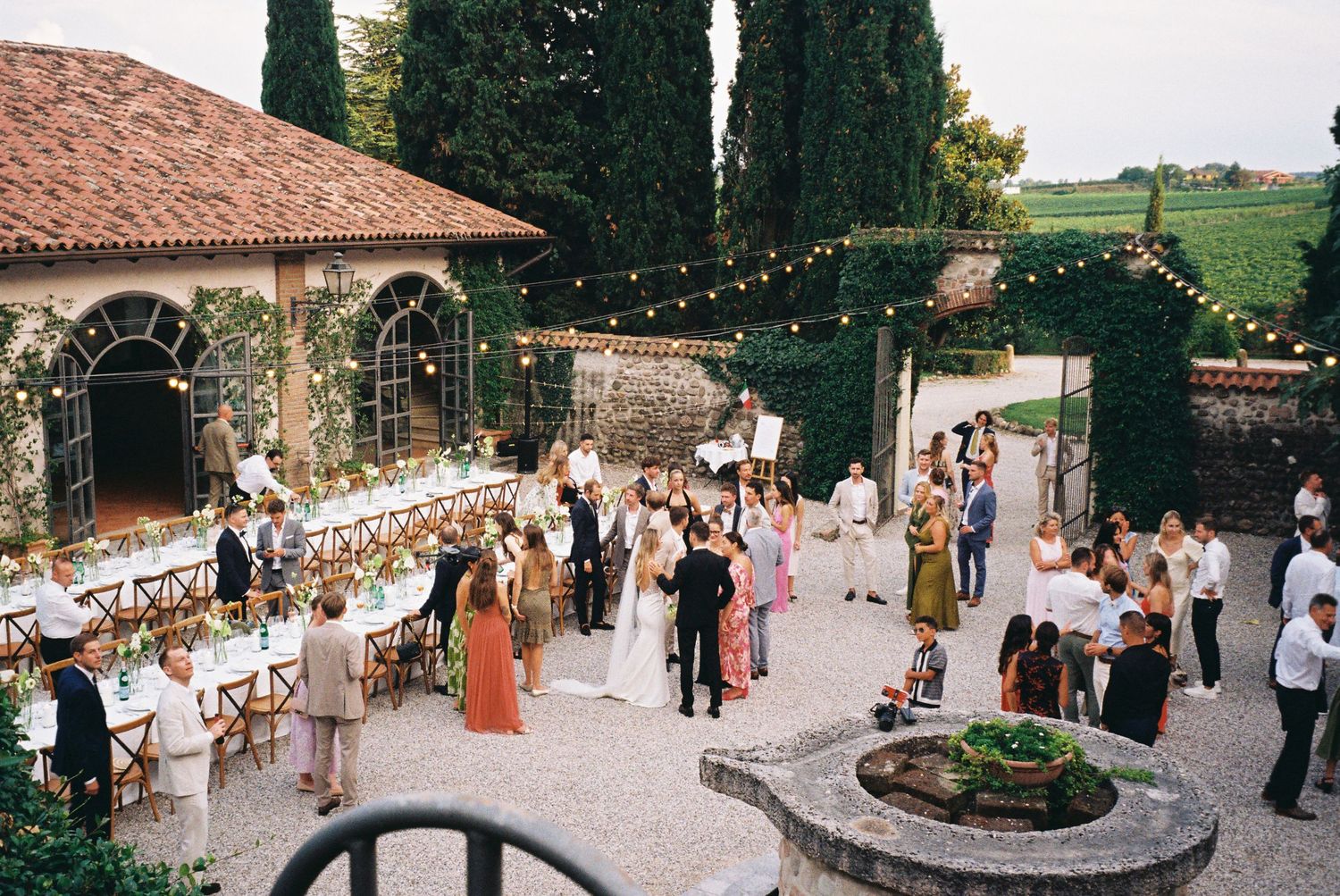 Outdoor wedding reception venue with string lights and Mediterranean architecture.