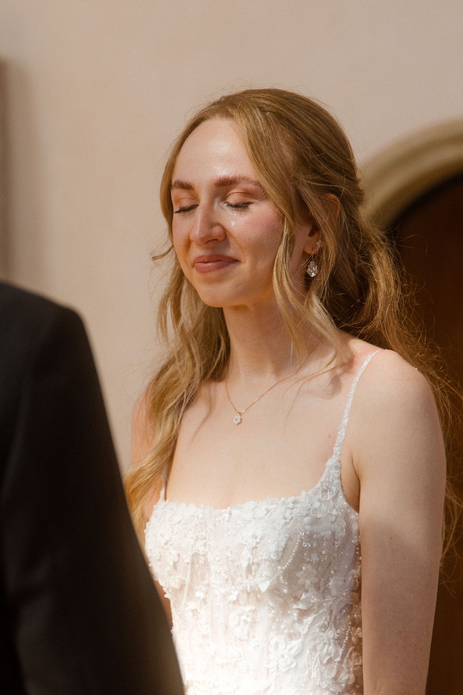 Close-up sequence of bride in white lace dress smiling naturally in soft lighting.
