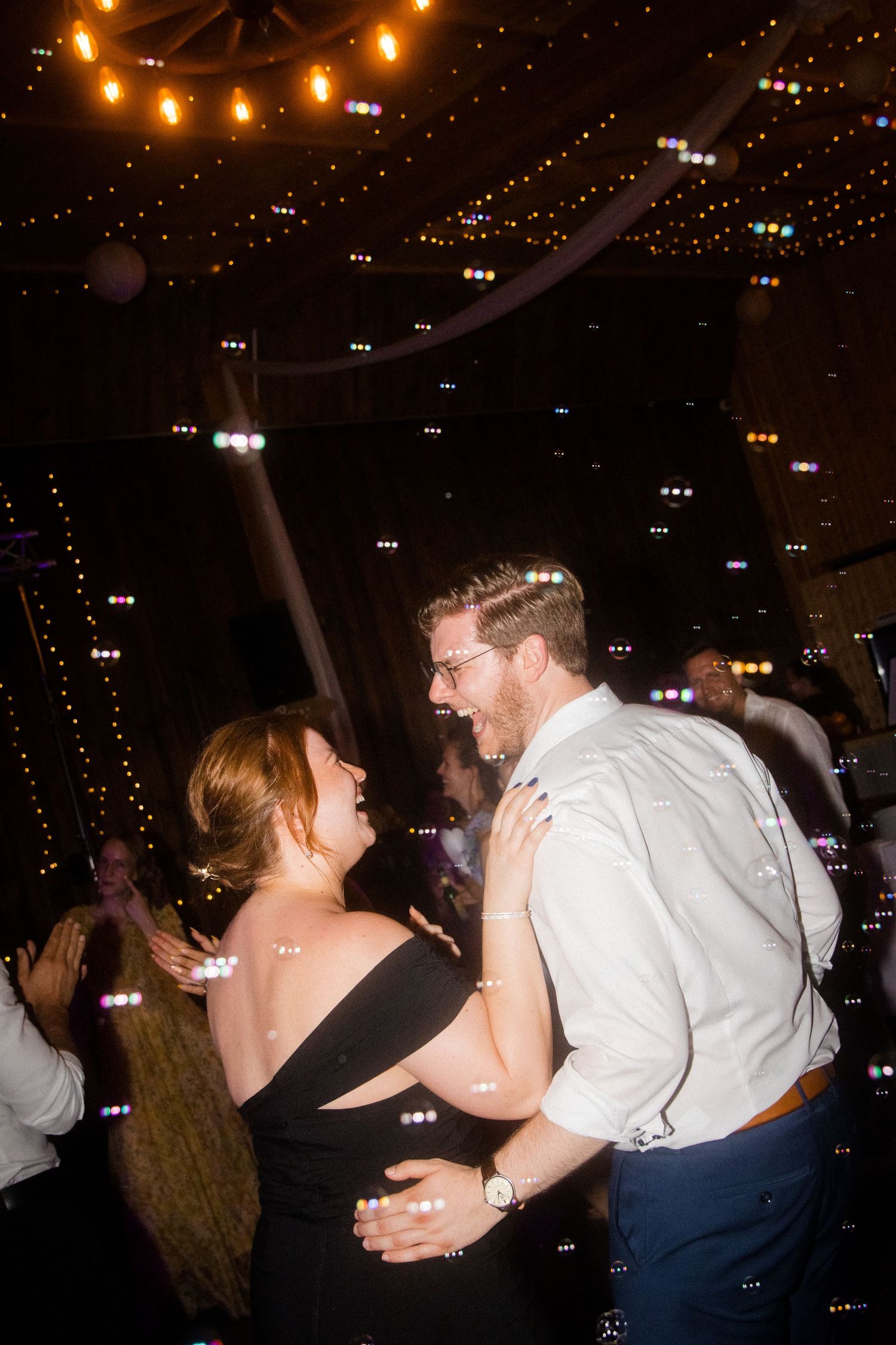 Wedding reception dance floor moments captured under warm ambient lighting.