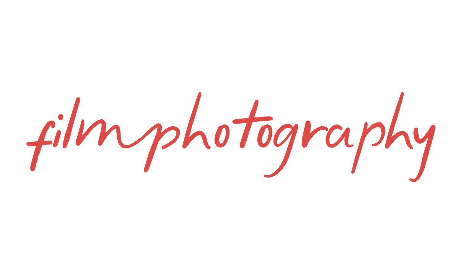 A handwritten text in red ink reads 'filmphotography' on a white surface.