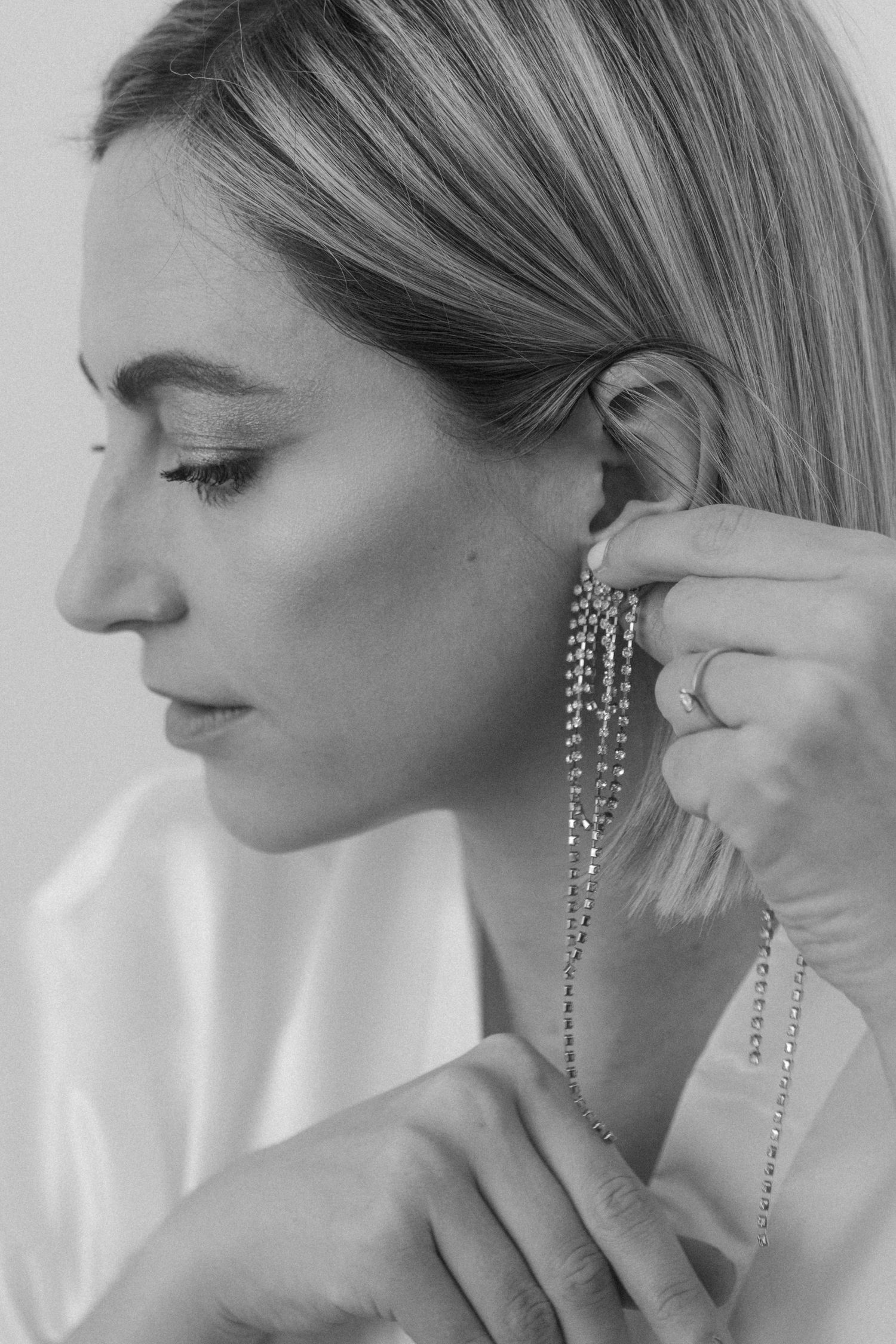 Side profile shots showing sparkling crystal drop earrings.