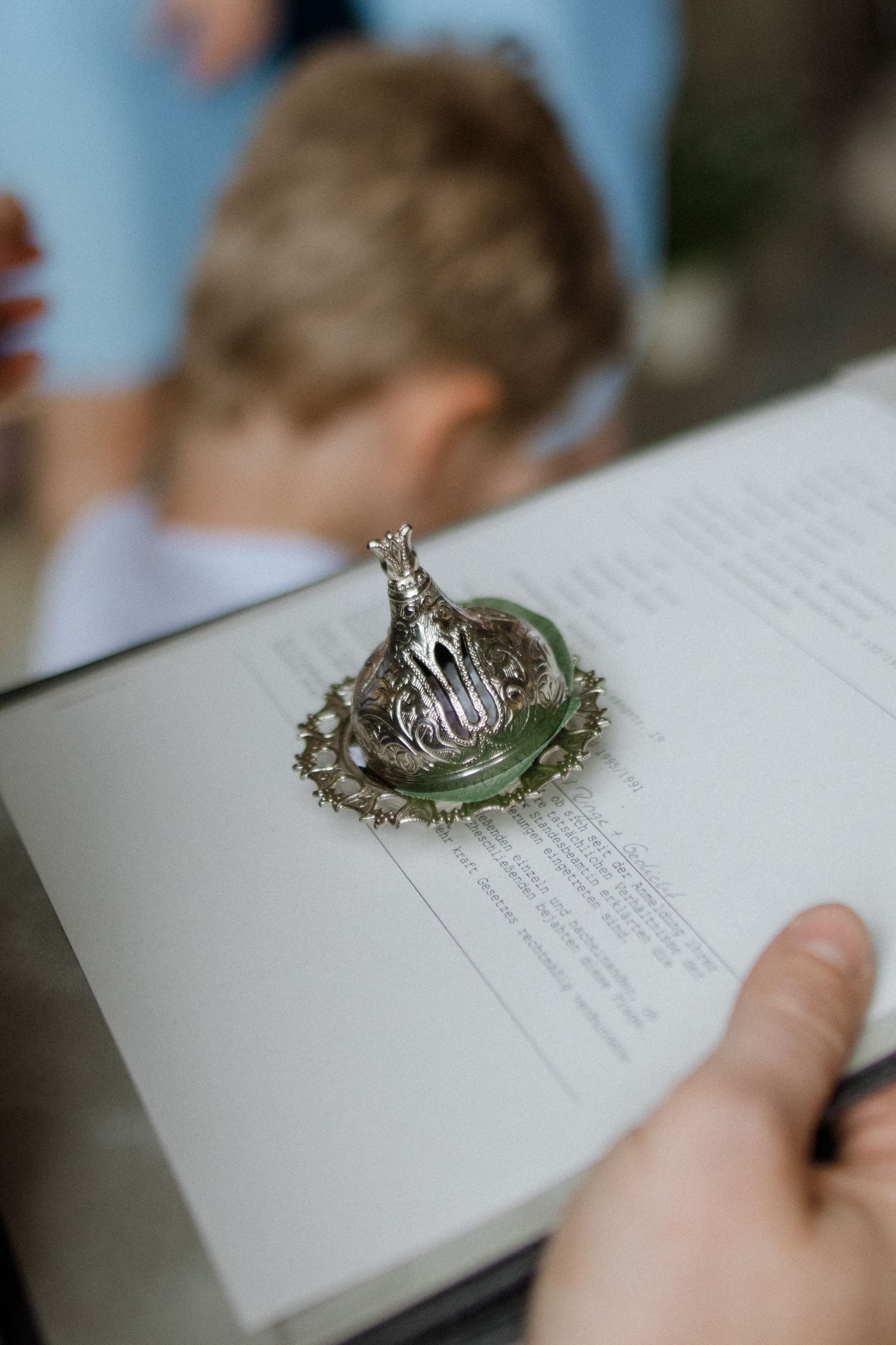 Wedding rings nestled in decorative dish atop ceremony text.