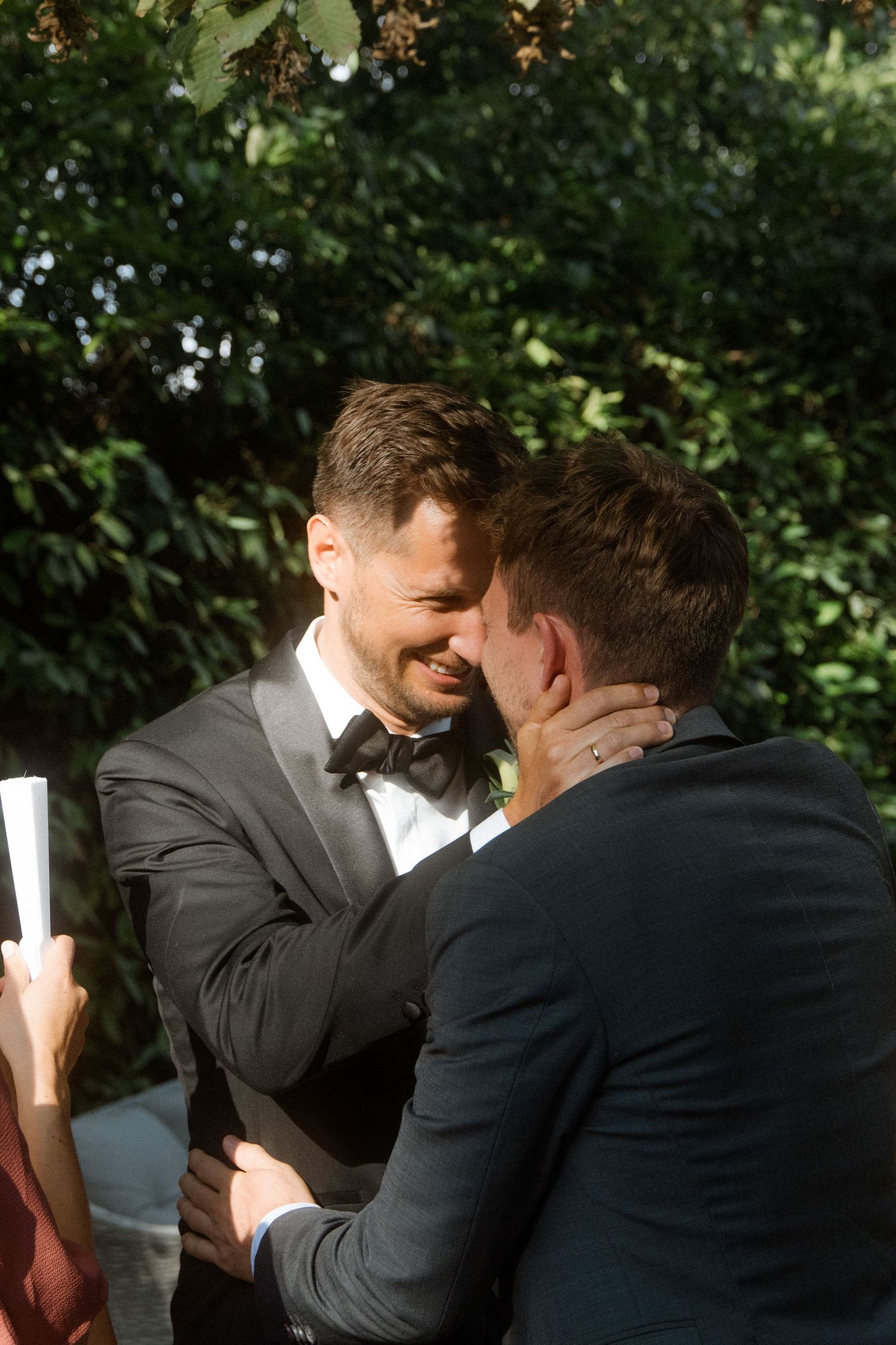 Emotional embraces shared during outdoor celebration in garden setting.