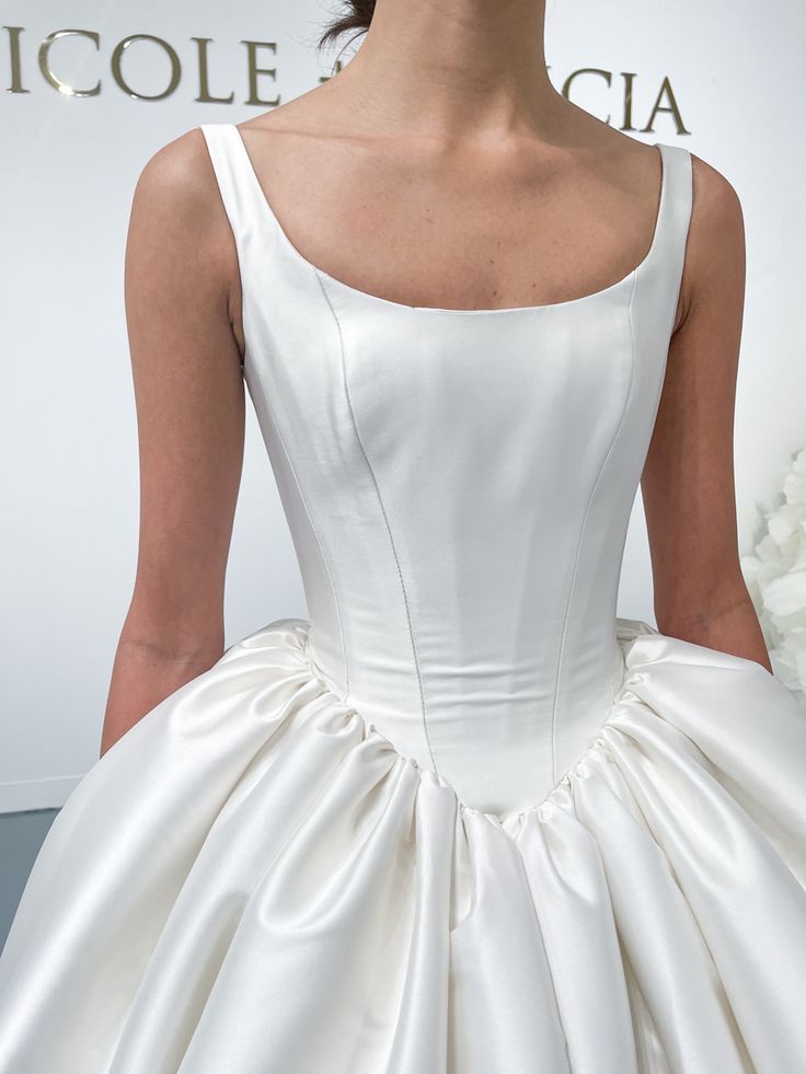 Close-up detail of structured white satin wedding dress bodice.