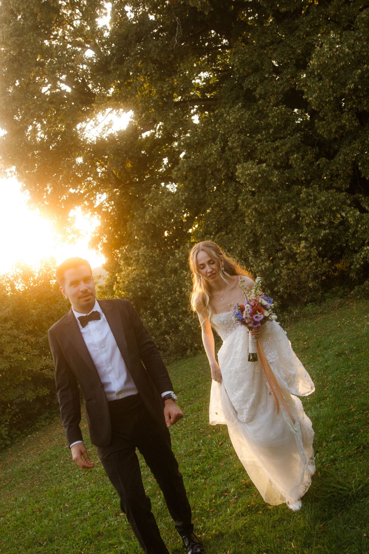Romantic sunset wedding portraits in garden with golden light filtering through trees.
