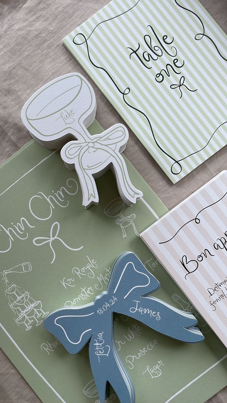 Wedding stationery featuring decorative bow designs in soft green and blue colors.