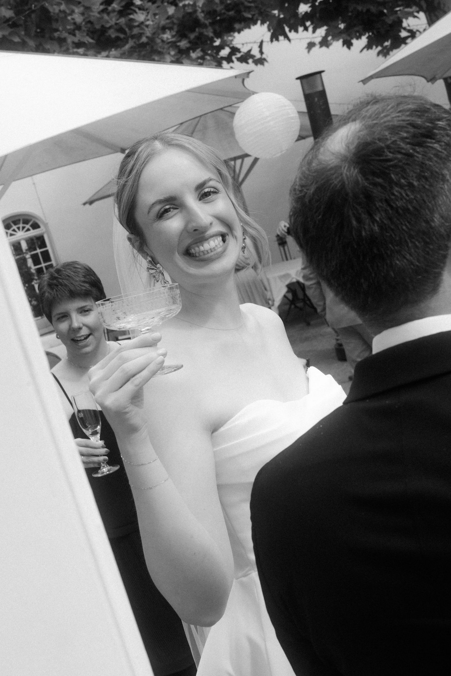 Wedding guests laughing and celebrating outdoors during a reception.