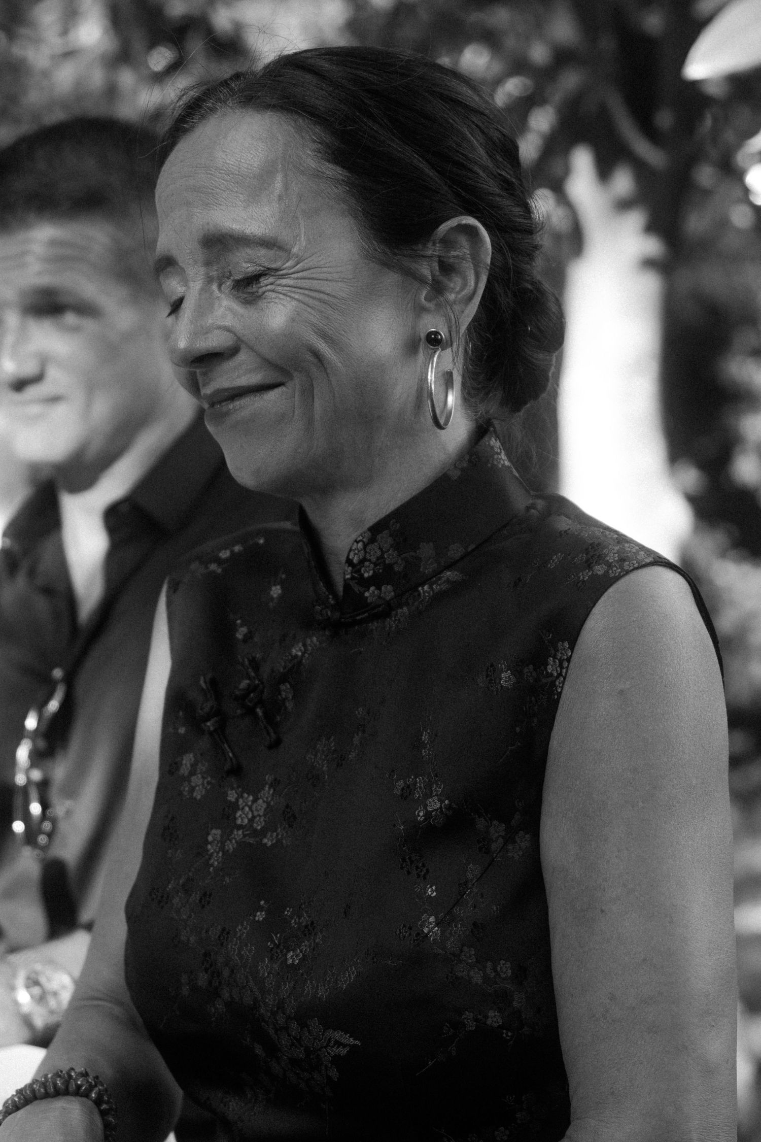 Black and white candid wedding photos showing joyful reactions and laughter during an outdoor celebration.