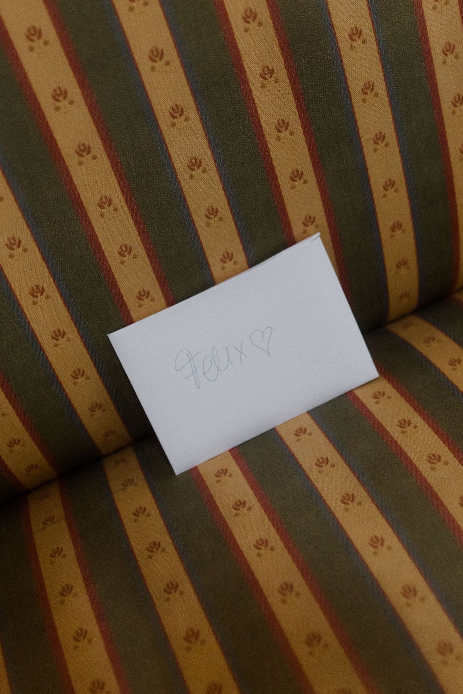 Close-up of white paper notes against a striped upholstered couch background.