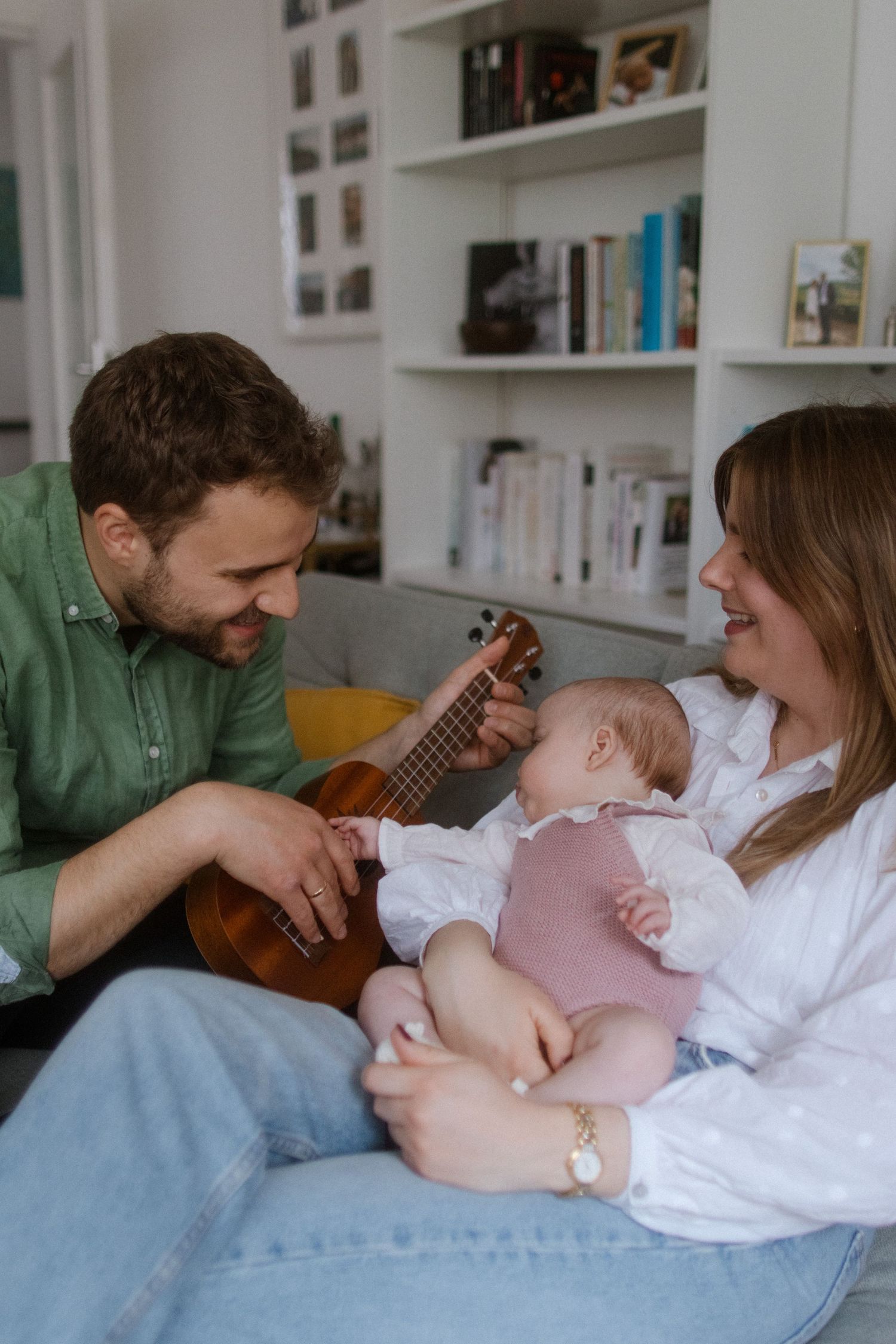 Family bonding time on couch with guitar music and gentle interactions.