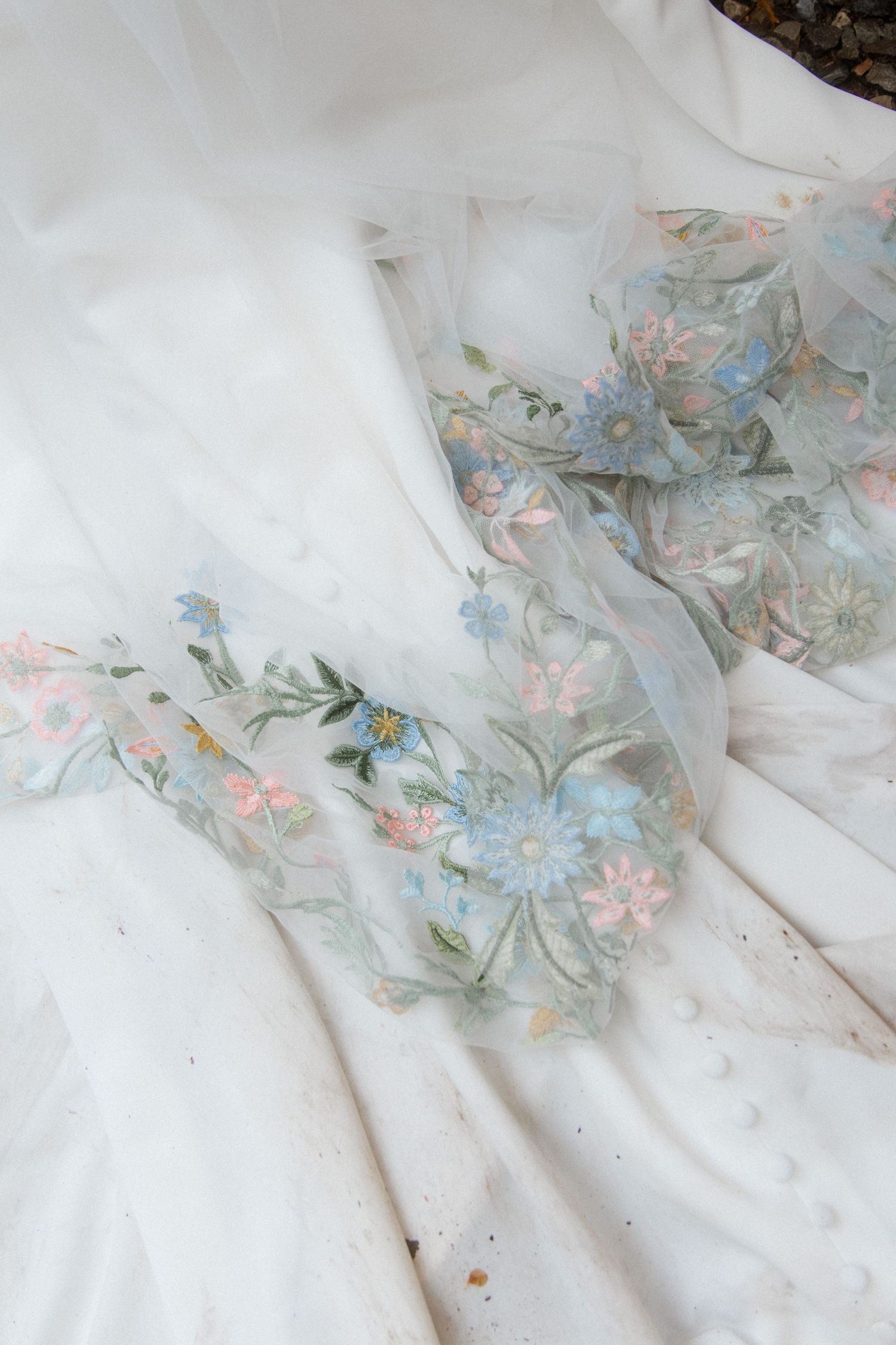 Delicate floral embroidery details on white wedding dress fabric.