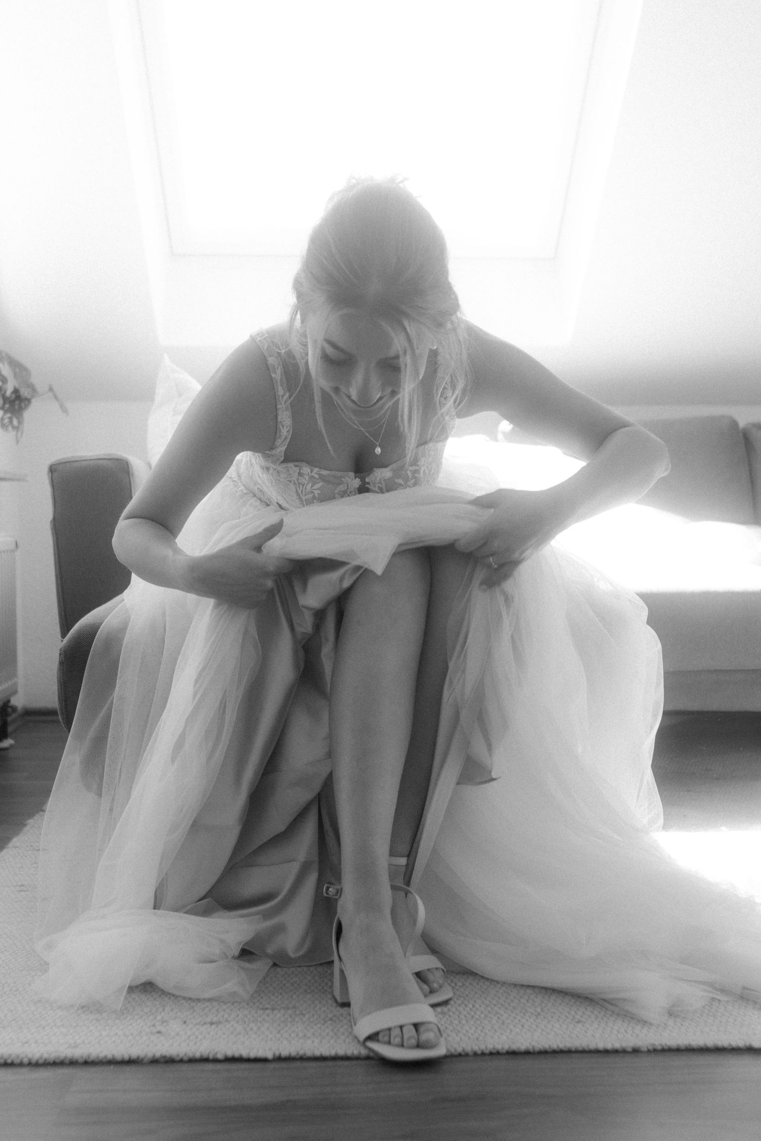Black and white image of final wedding preparations with elegant dress details.